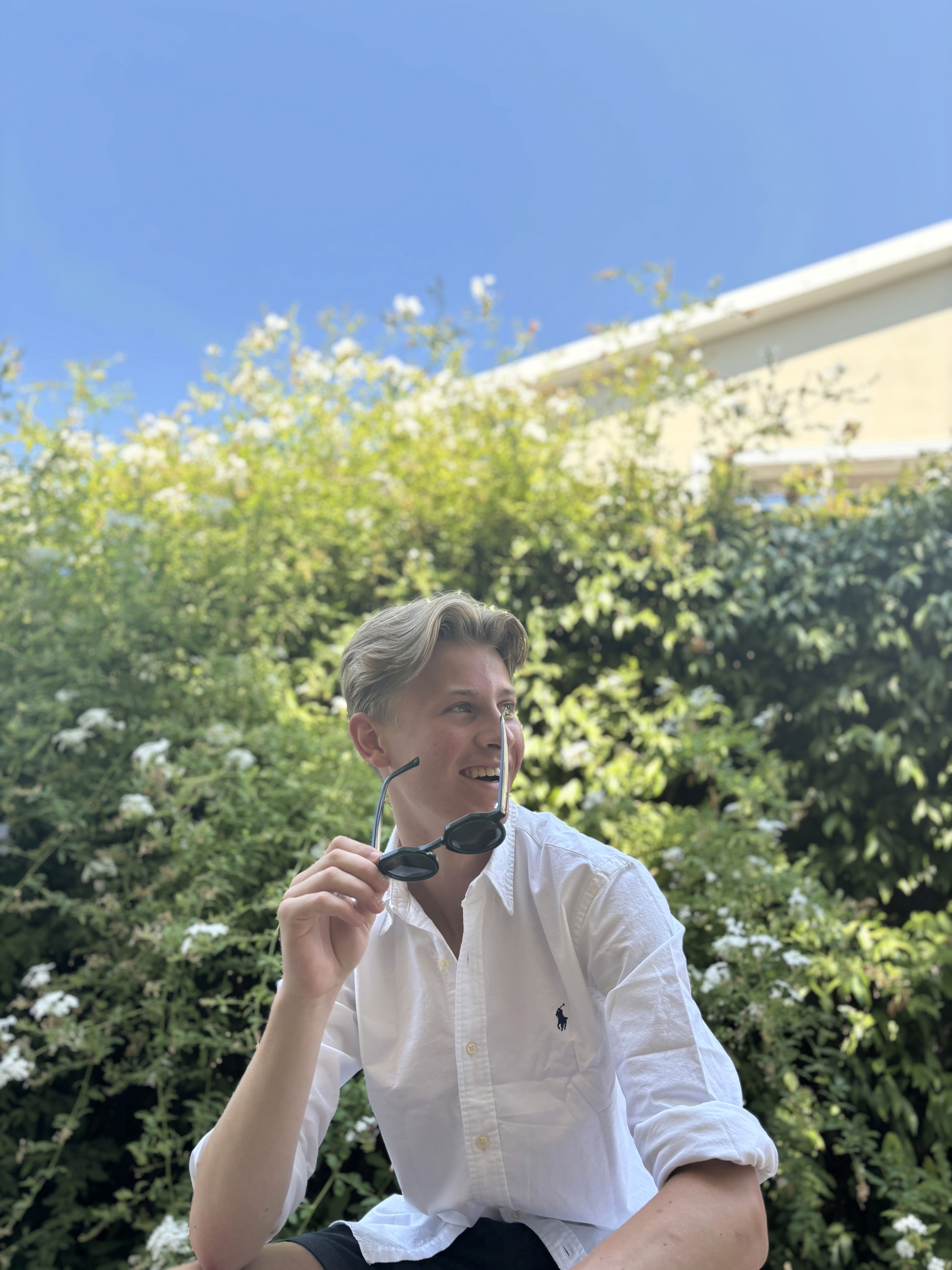 Profile portrait of a man in a white shirt against a light background