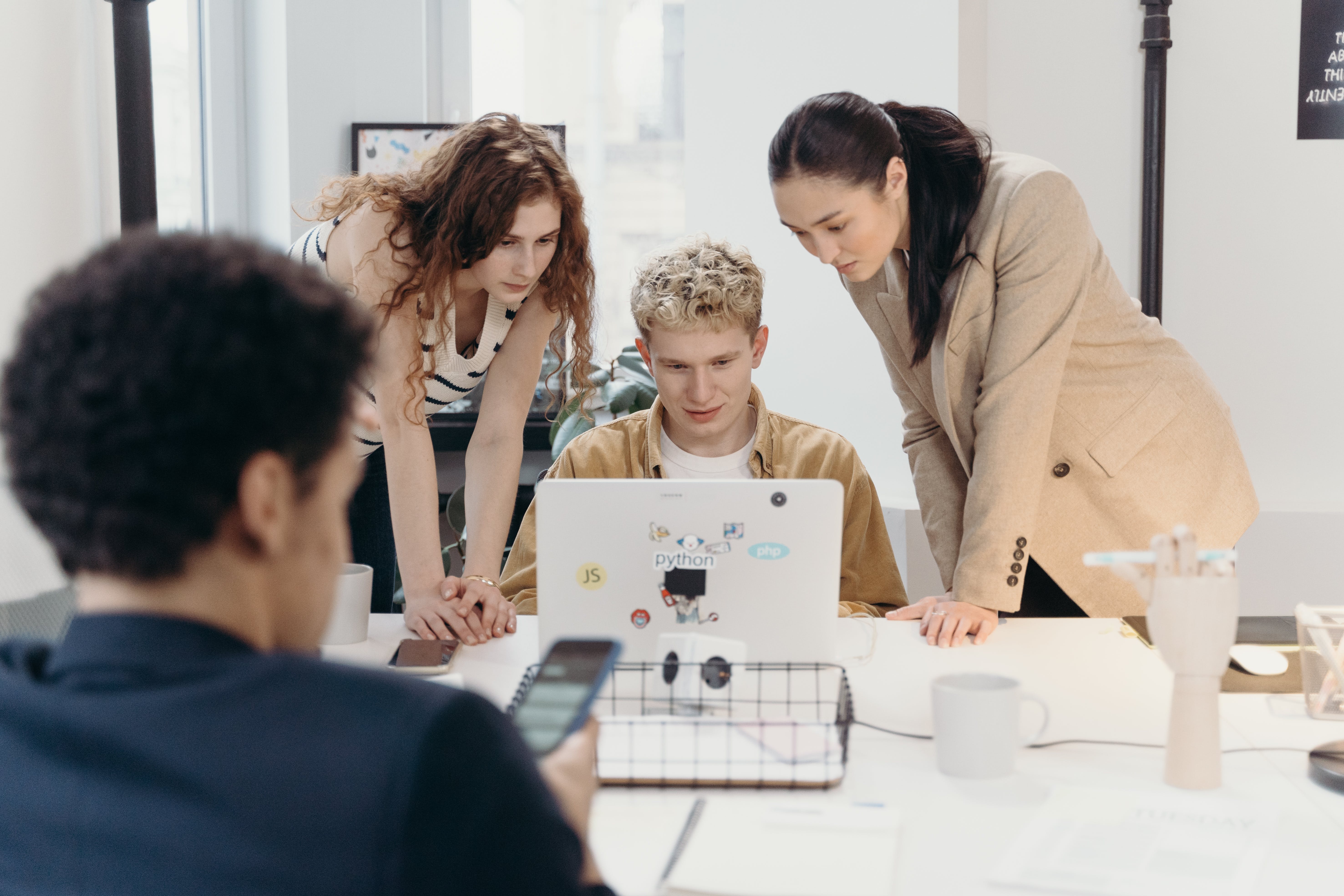 Women standing beside a man creating a cold email agency