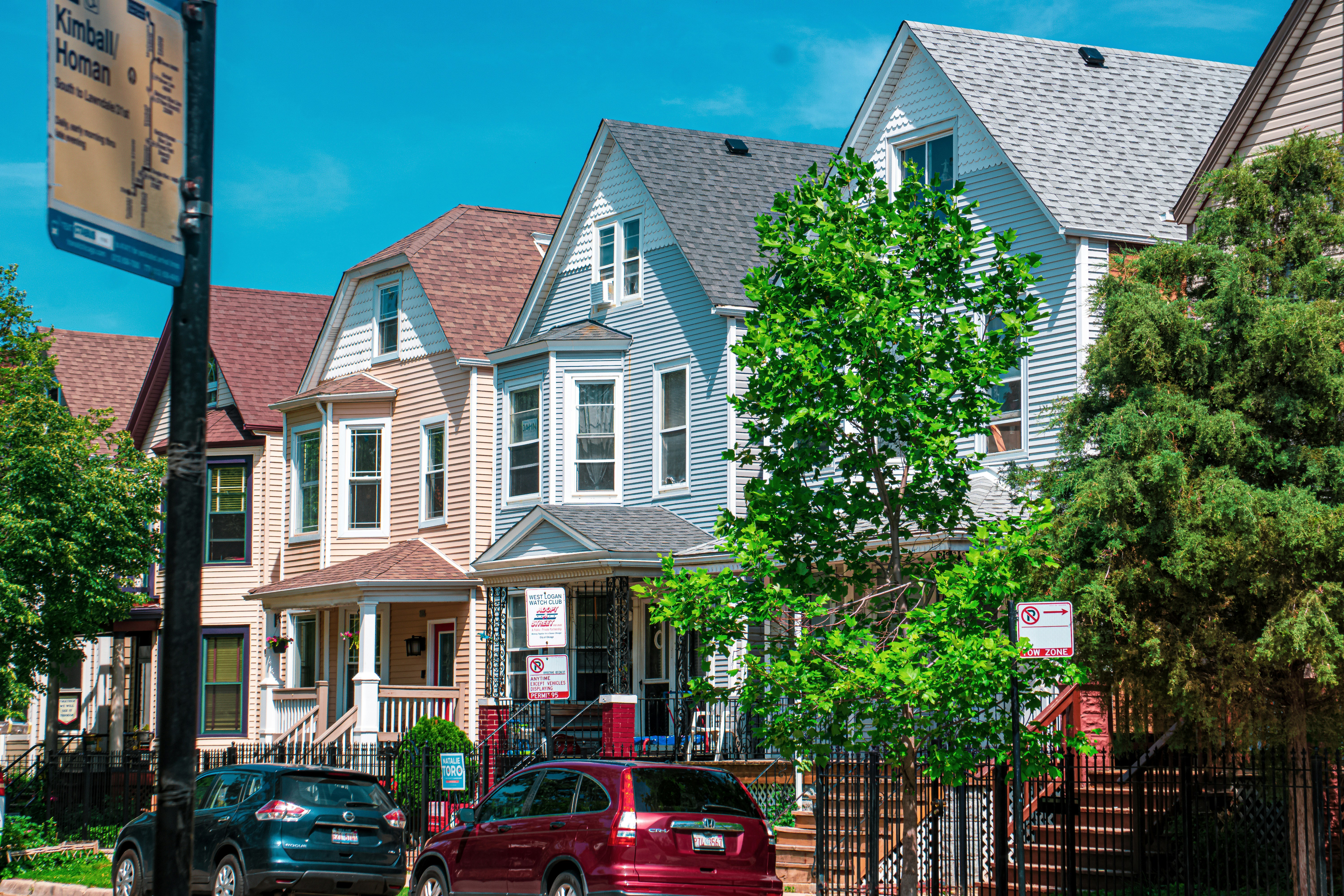 a row of houses with cars parked in front of them