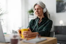 femme senior avec un casque et ordinateur