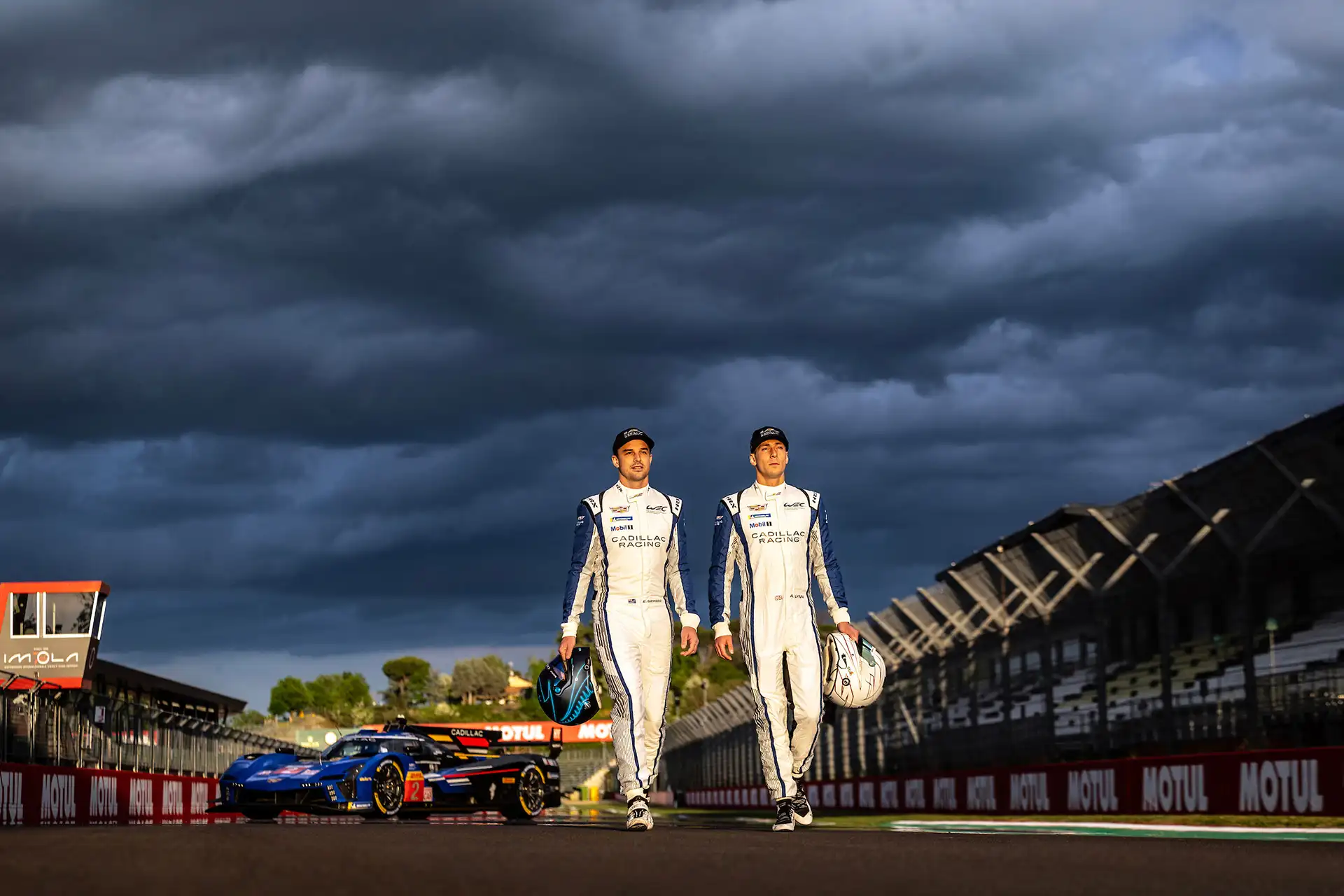 Two drivers walking away from their racecar.