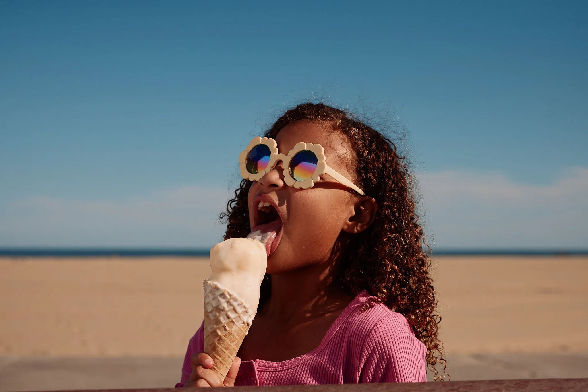girl licking melting ice cream cone — lifestyle photography by Tom Kubik