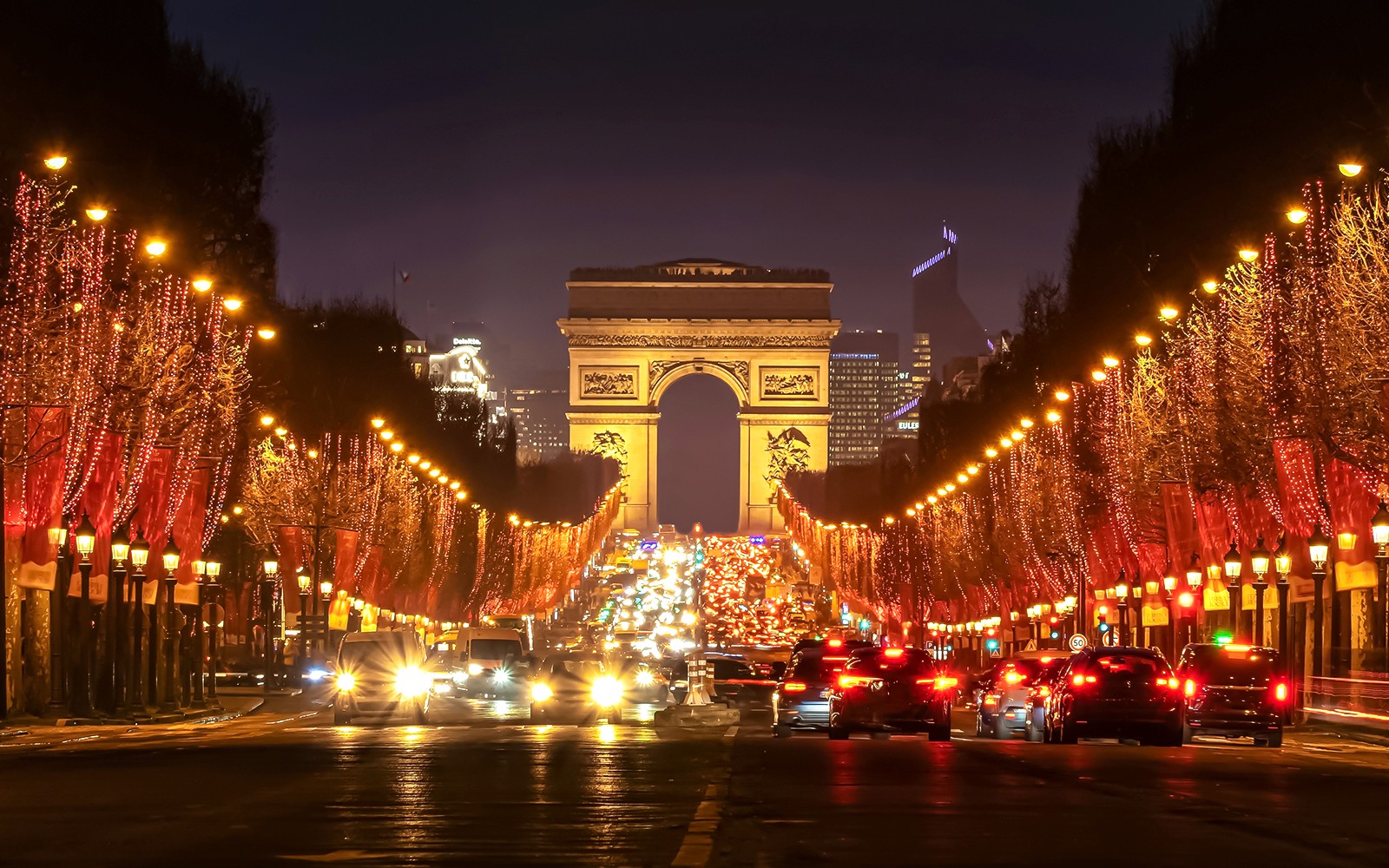 凱旋門を背景にした夜のシャンゼリゼ通りのイルミネーション。