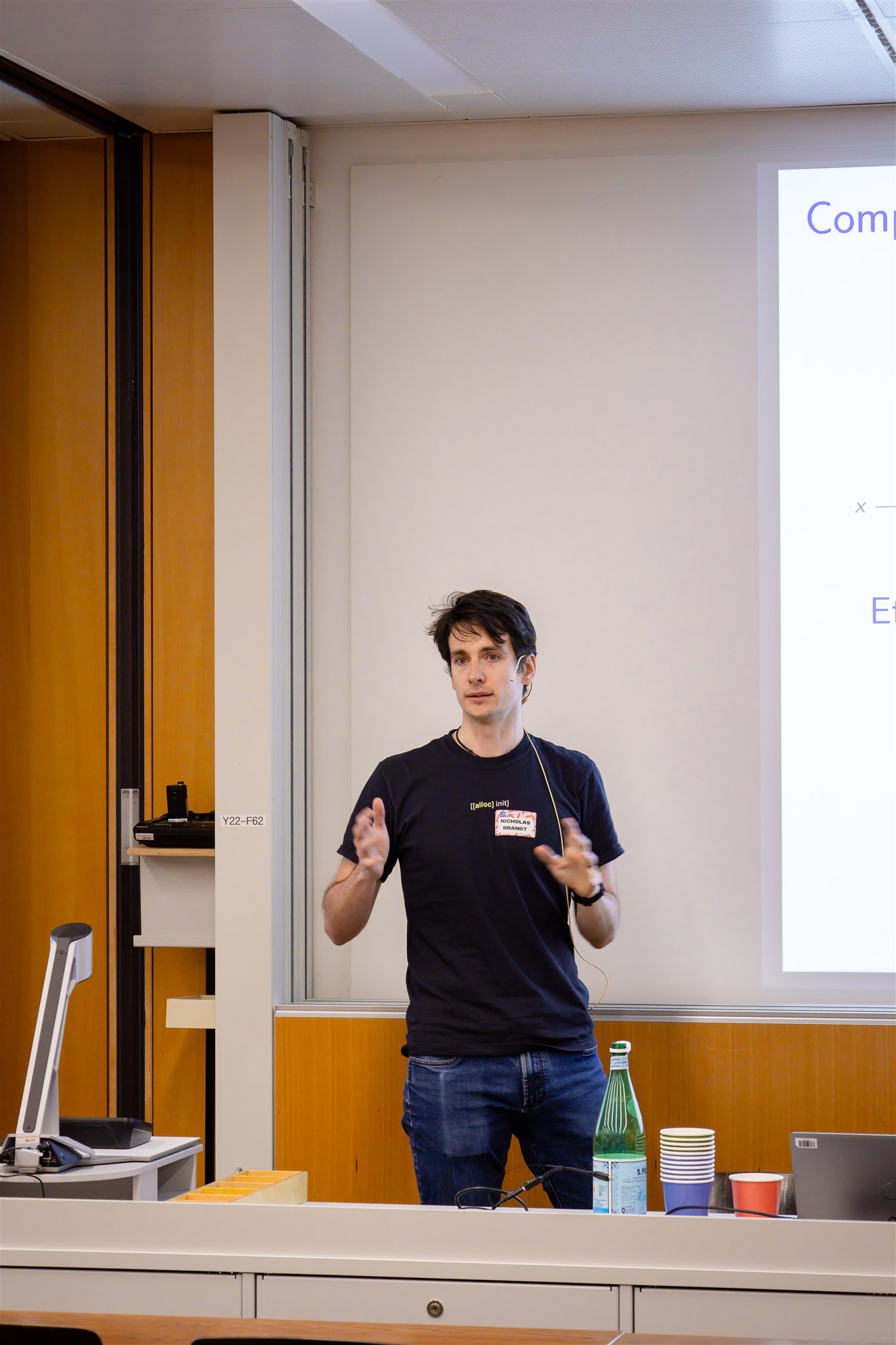Speaker presenting on stage during EthereumZüri event in Zurich lecture hall