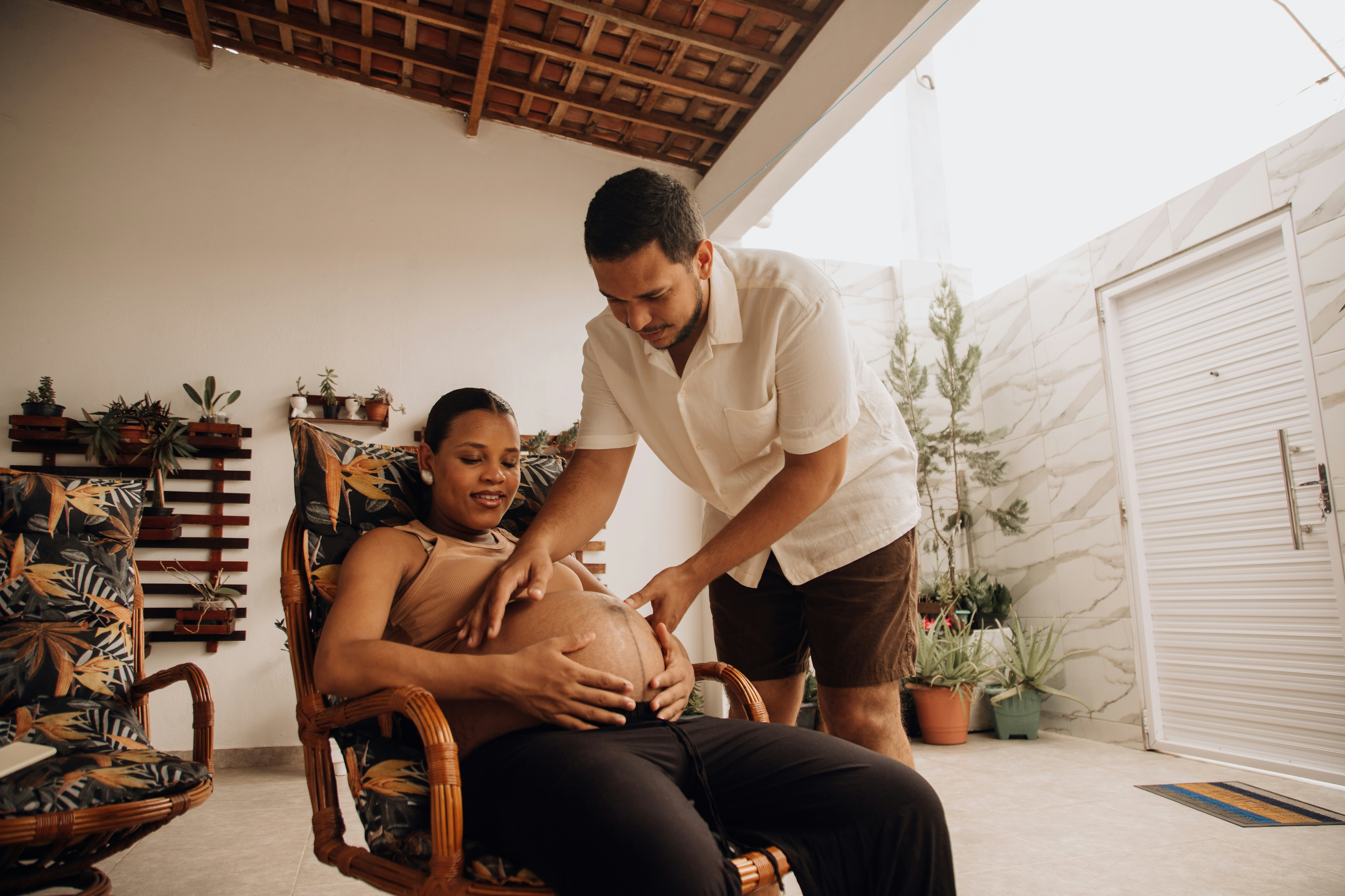 a pregnant woman sitting in a chair being examined by a man