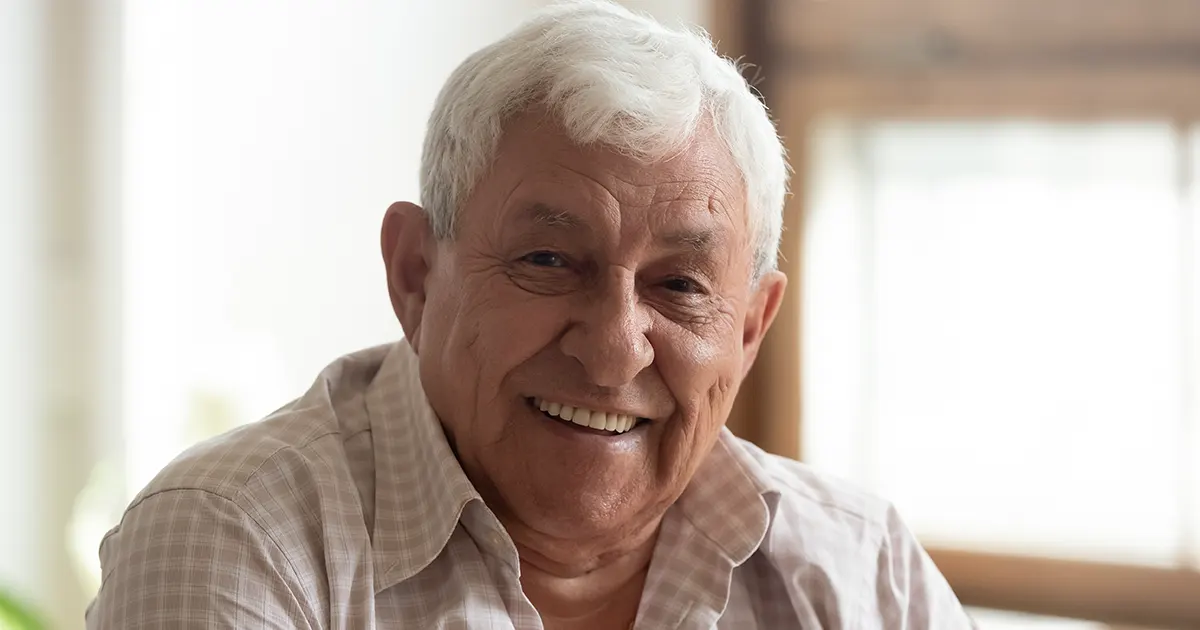 Bilde av mannen på 70 år som smiler og er glad.