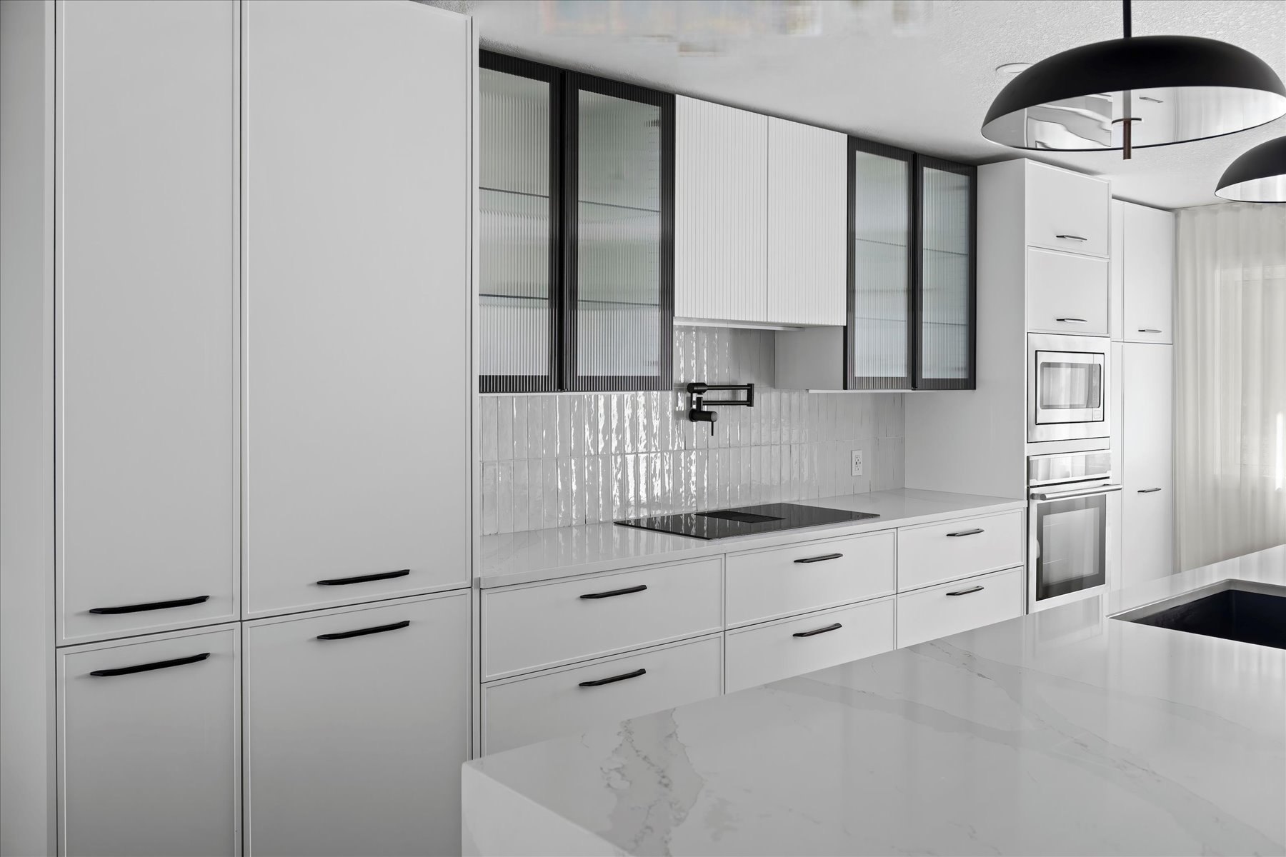 Strathcona kitchen after the HAUS Interiors renovation: slim shaker cabinetry, black-framed glass uppers and Calacatta quartz counters
