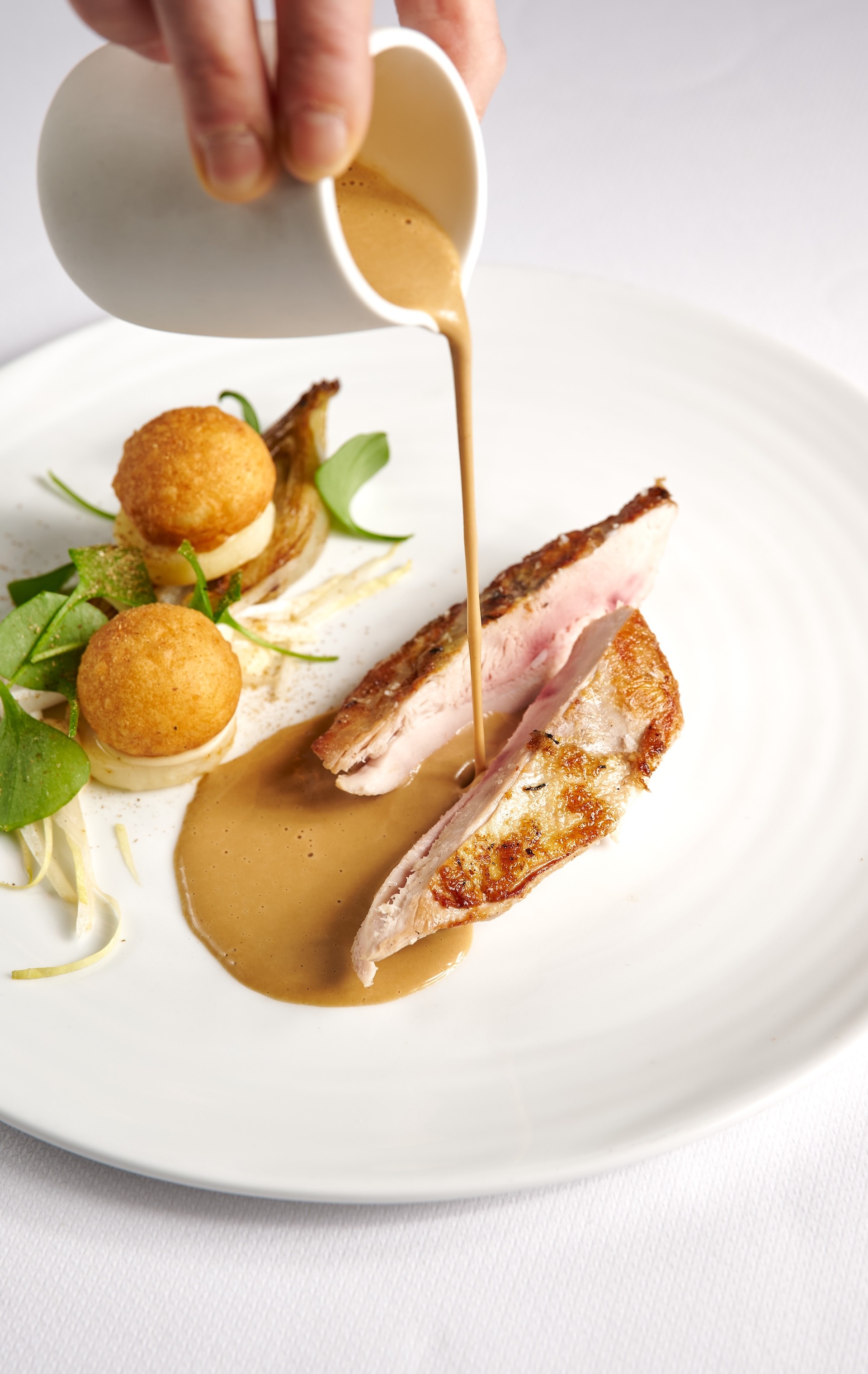 Succulent main course served with a rich reduction sauce and side garnish