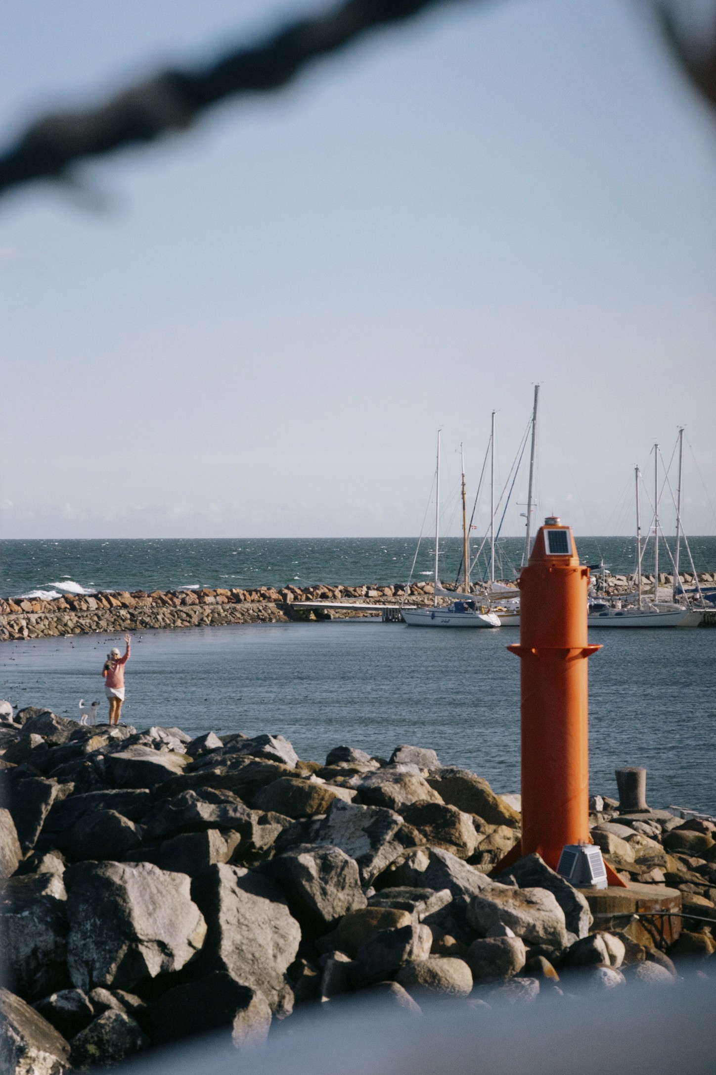 person waving hello from land to the passengers on the Anholt ferry