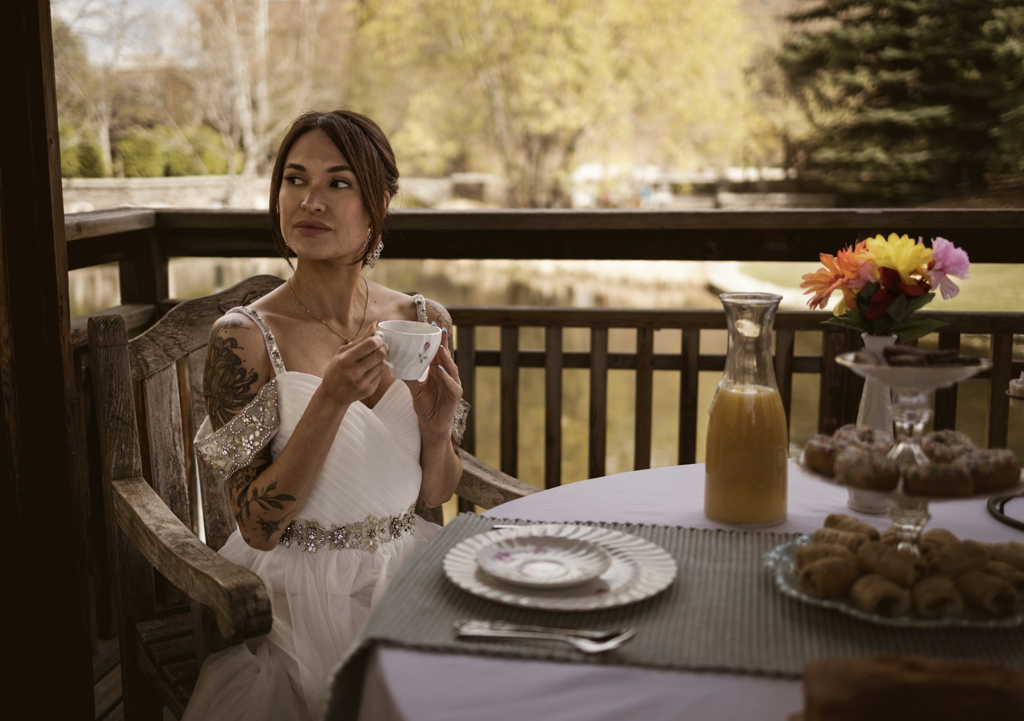 A guest with a cup of coffee at a laid breakfast table on the terrace