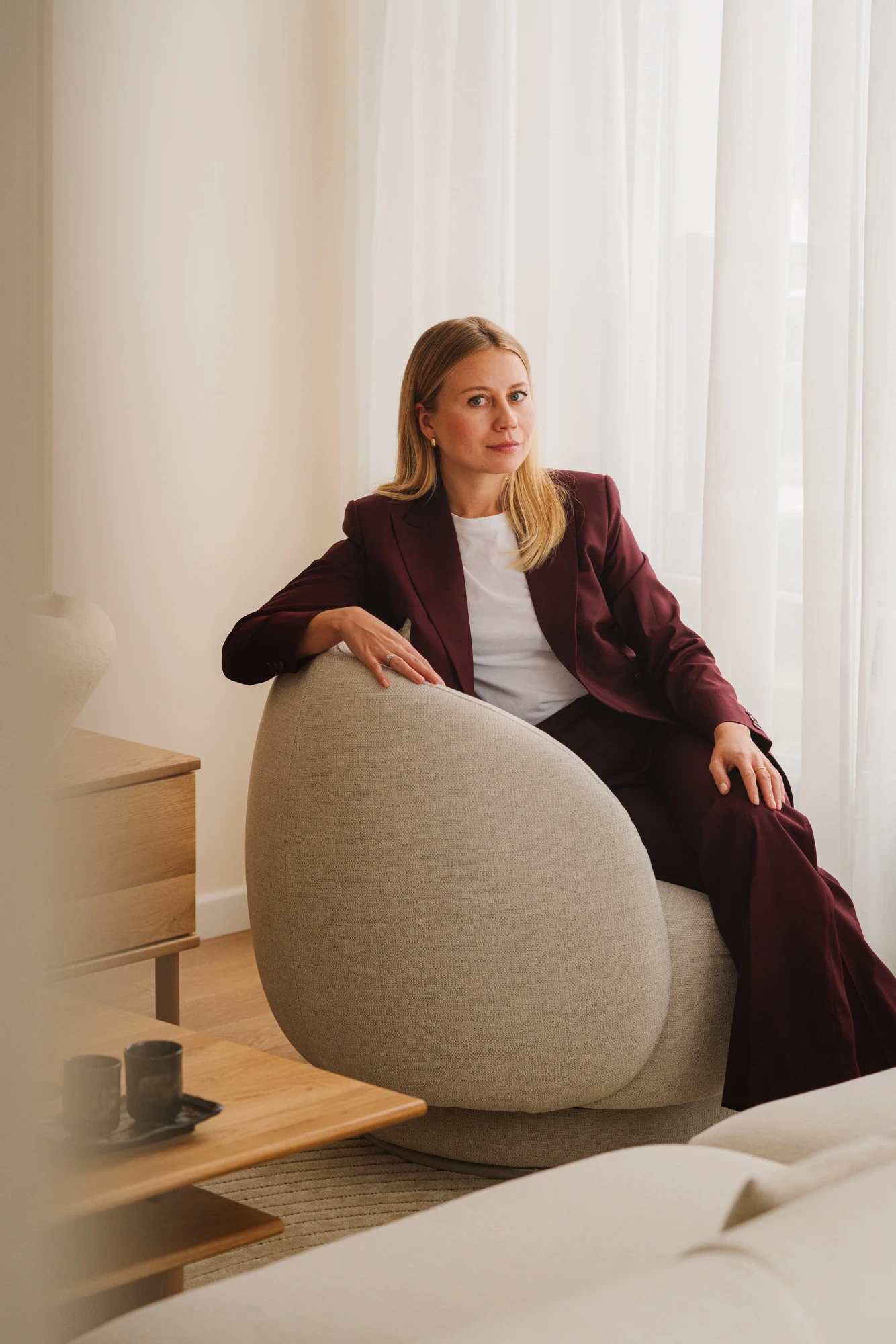 Portret architektki Lund Architects Atelier siedzącej we wnętrzu zaprojektowanego domu.