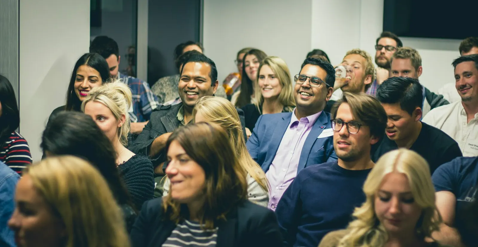 A smiling audience listening to a talk