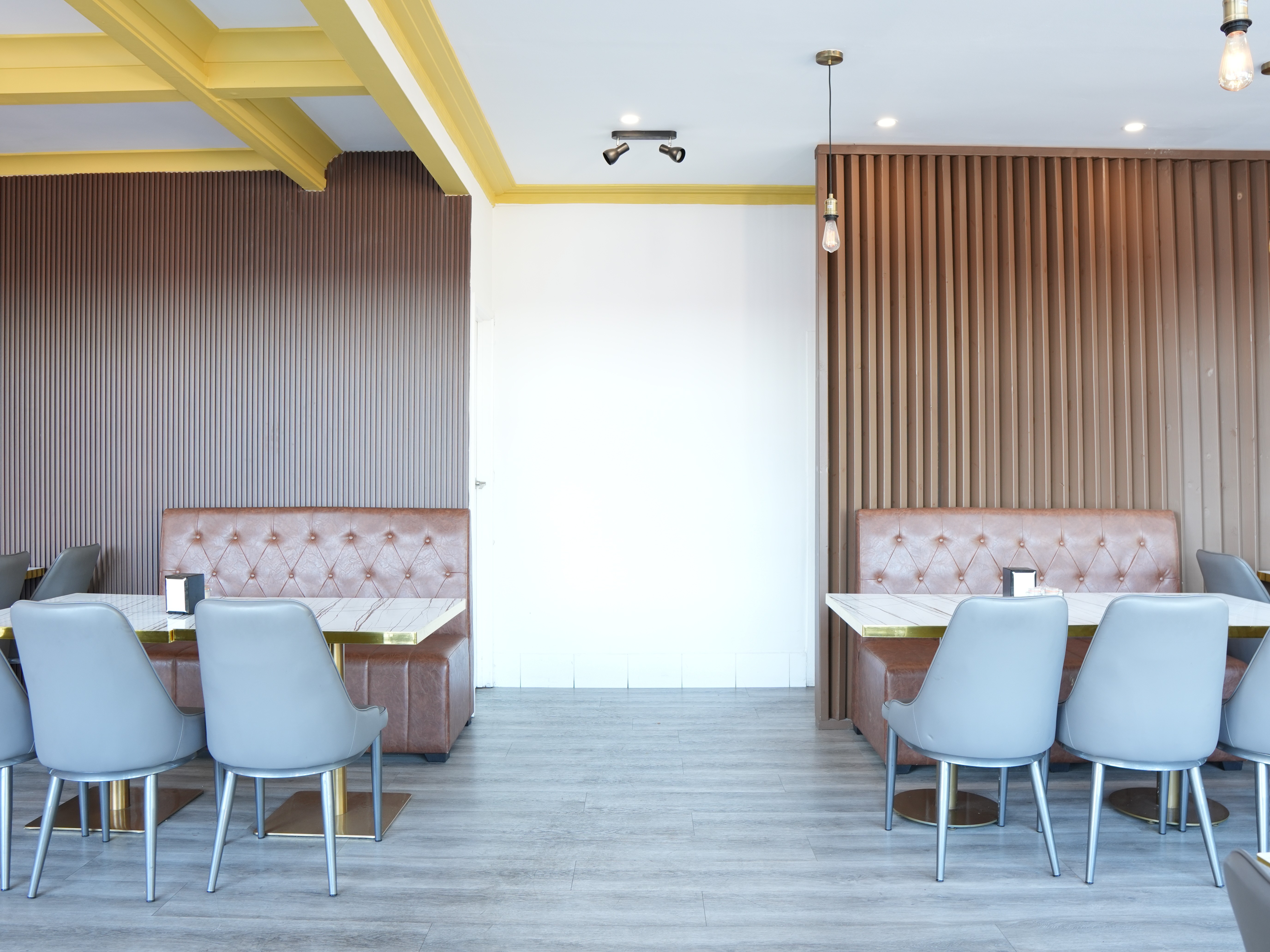 Hospitality fit-out for Heyburg in Coburg, Victoria with neon Hey'Burg signage, terrazzo counter, custom pop-art murals, brass pedestal tables, pendant lighting.
