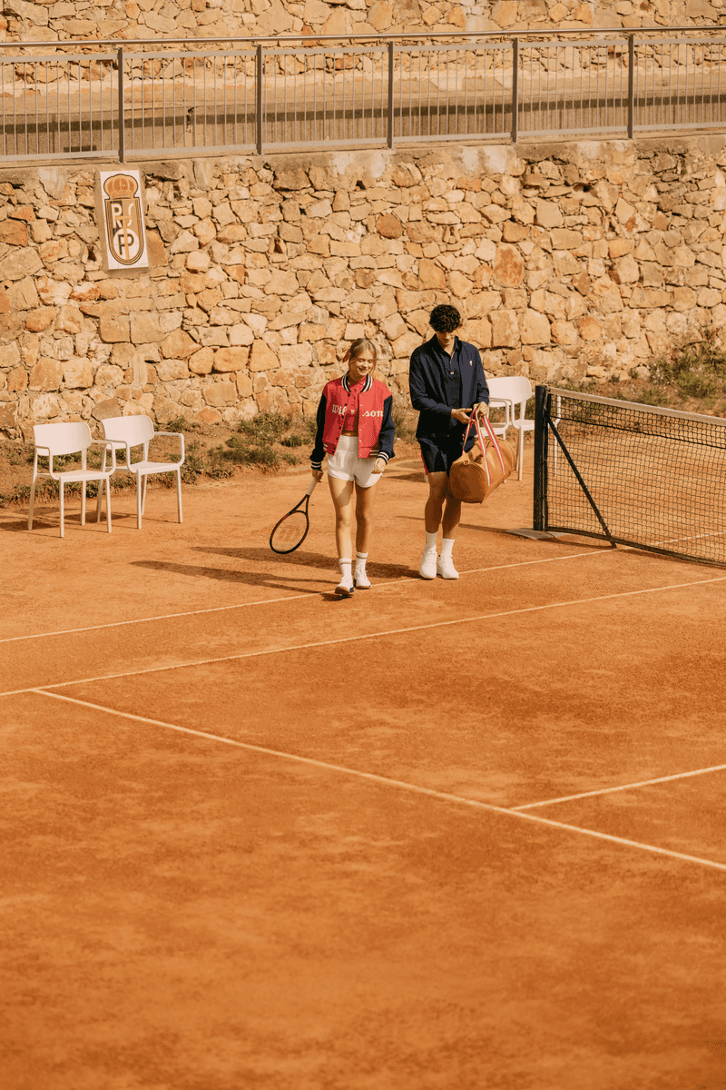 Vue de loin, deux mannequins du lookbook Wilson Courtstyle portant blousons, shorts et jupe de la collection inspirée par le tennis