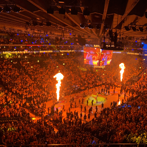 man in white sweater holding round mirror