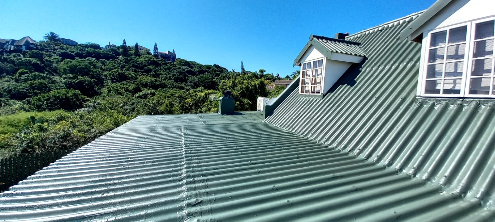 House roof getting sprayed with waterproofiing rubber