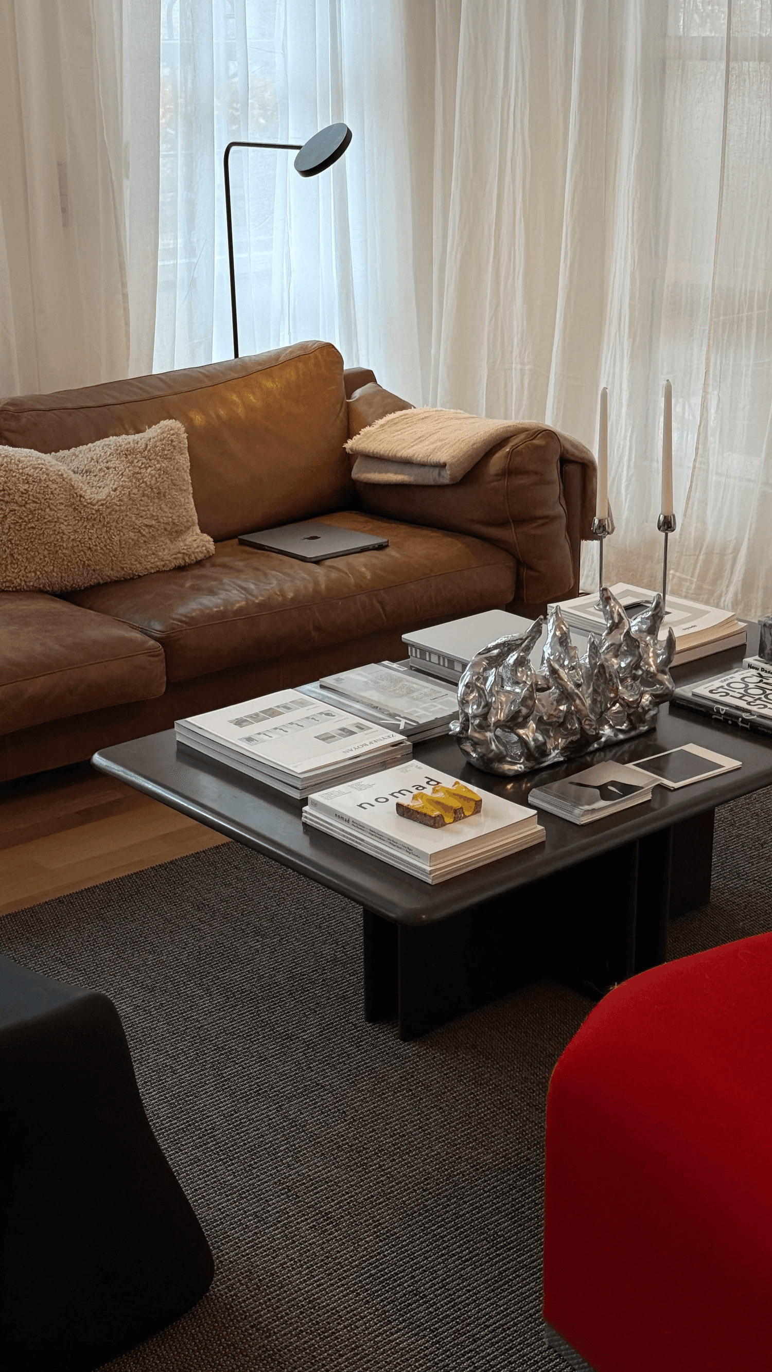 Couch and coffee table with books and decorative items in a dimly lit living room setting.