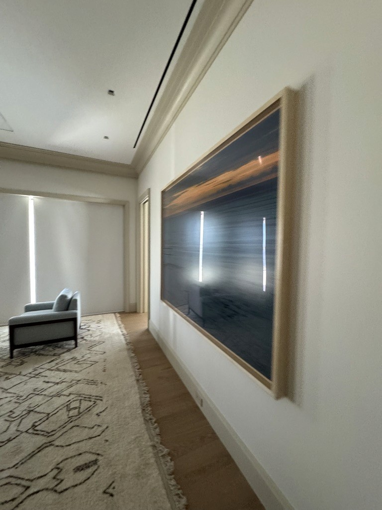 Large abstract photographic artwork installed in a hallway beside a lounge chair