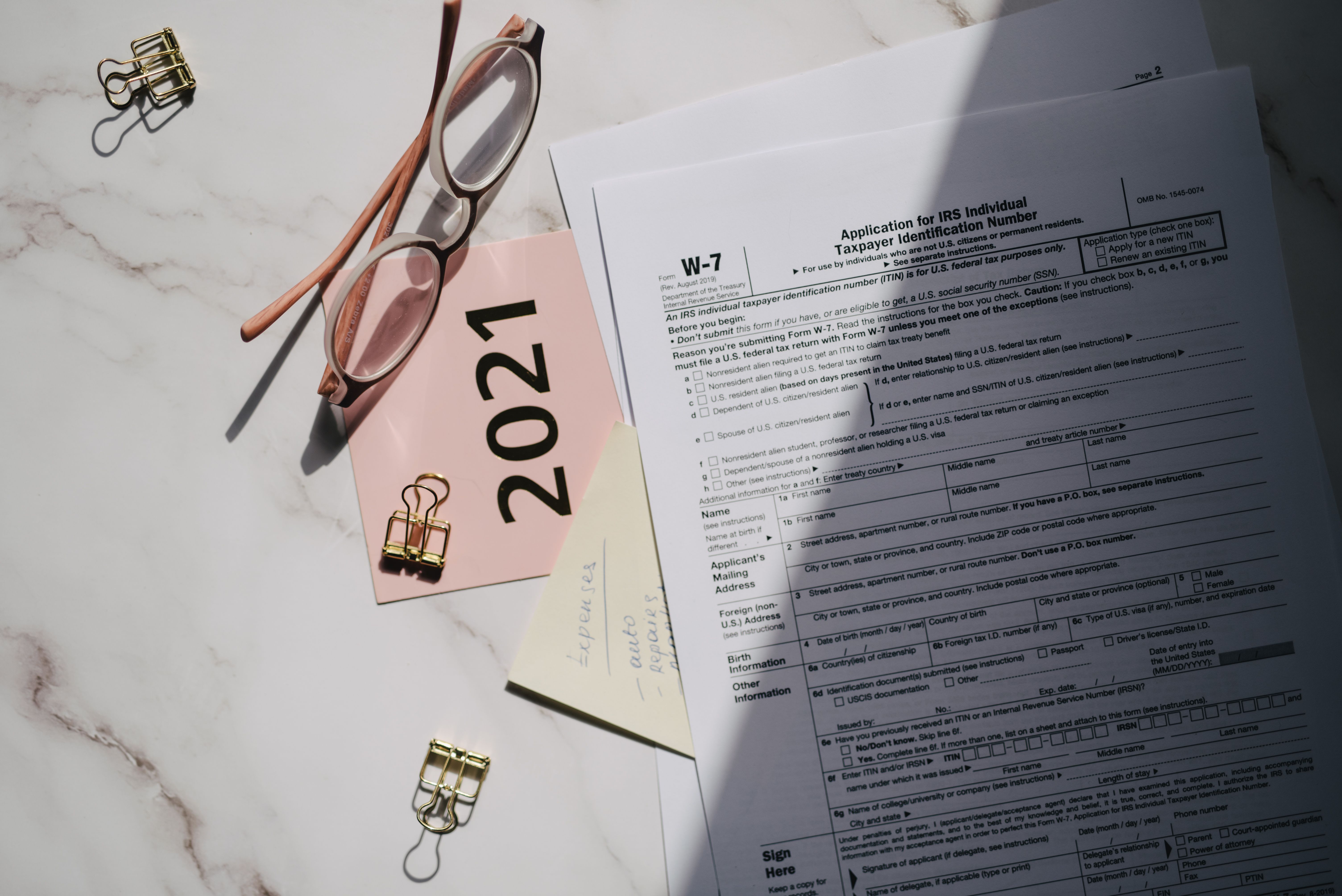 Documente fiscale cu ochelari pe birou, analiză plafoane 2026 microîntreprindere TVA și mijloc fix în contextul OUG 89 și OUG 8