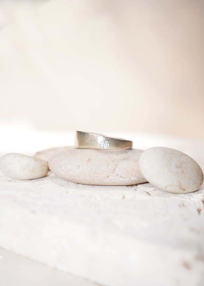 Silver ring on a stack of white stones with a blurred background