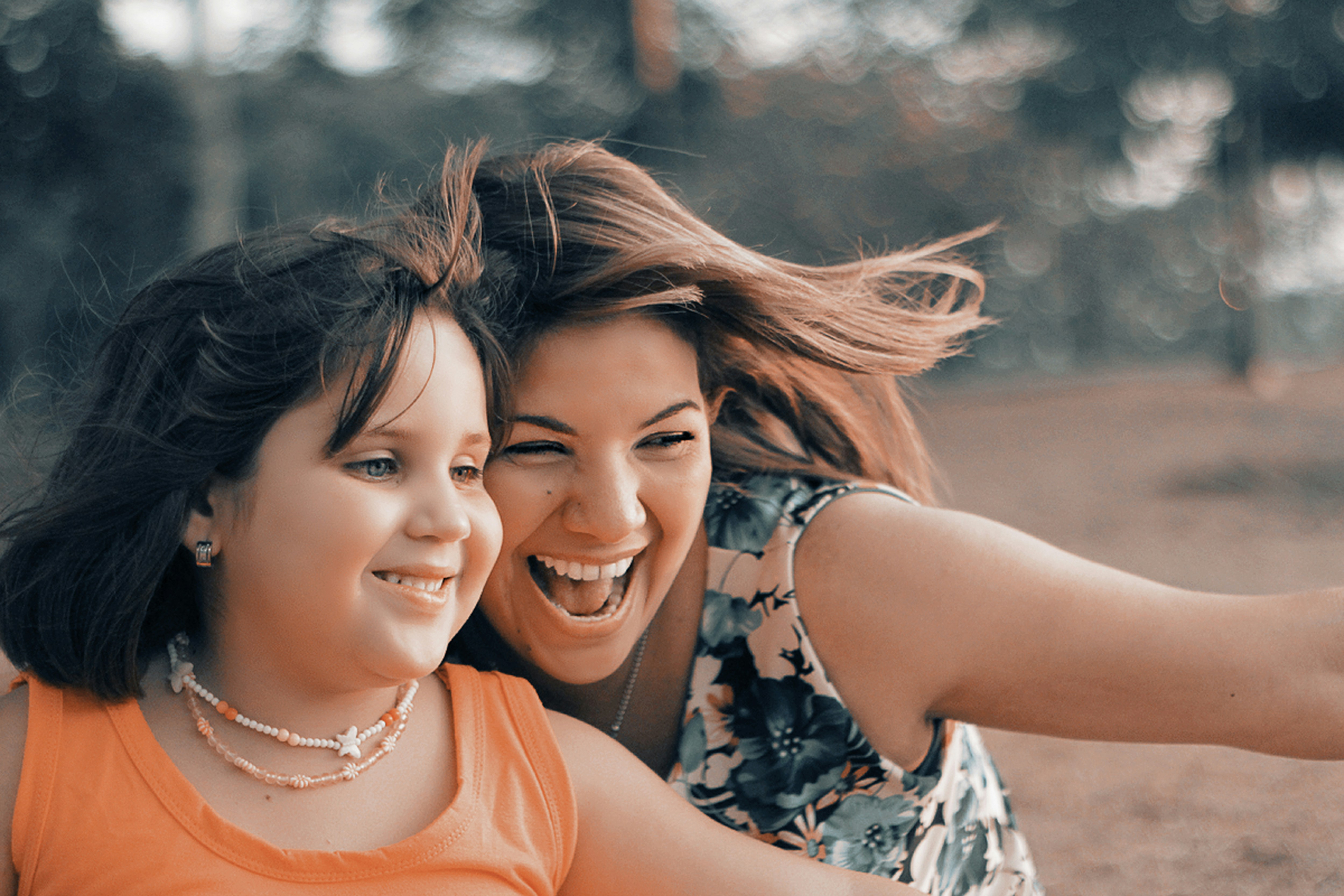 Woman laughing and enjoying time with daughter after recovering from cosmetic surgery