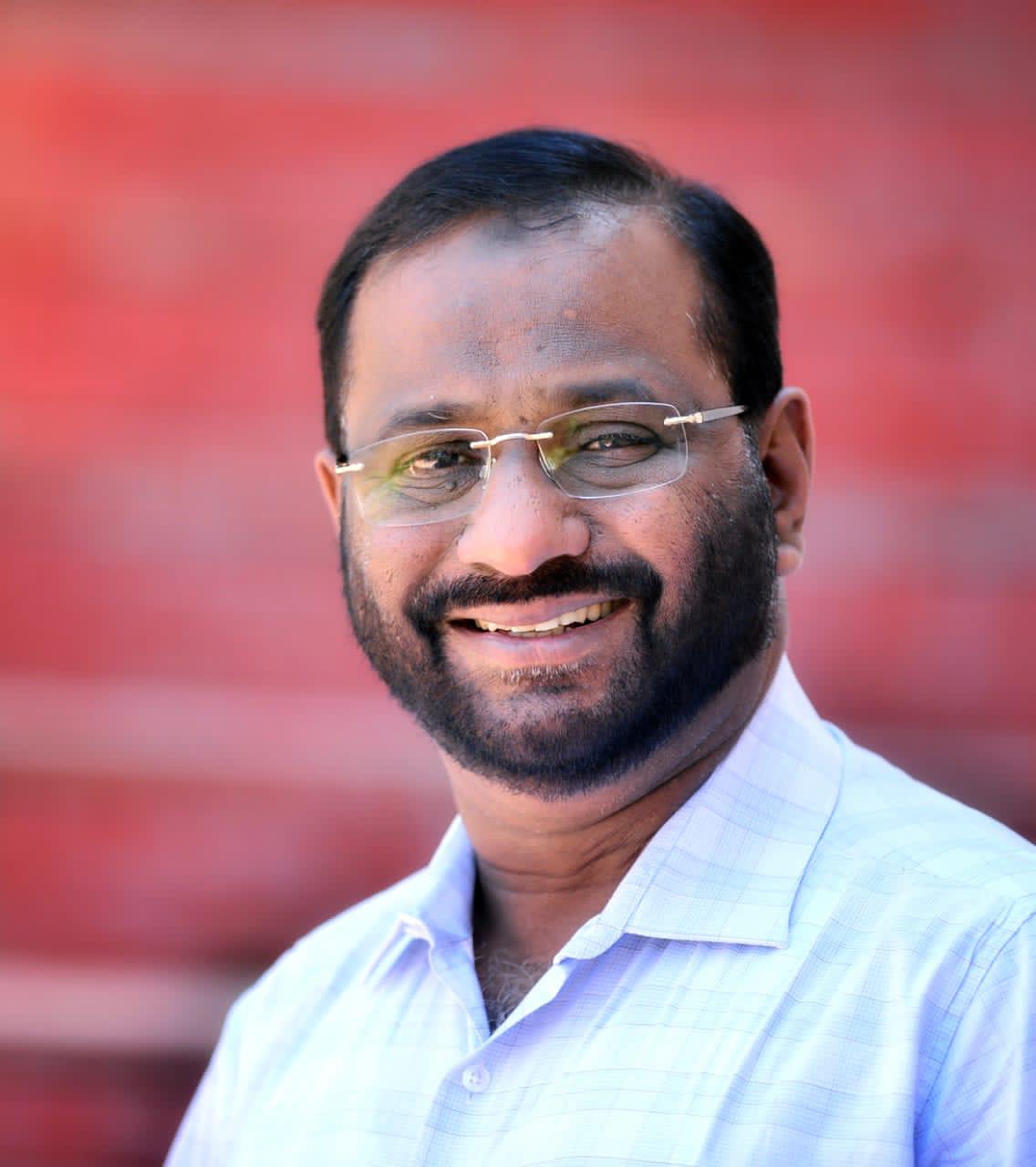 A portrait of Dr. KP Khalid, CEO and Founder of Au Revoir Wellness Resort, Malampuzha, Palakkad, captured with a warm smile and a confident presence