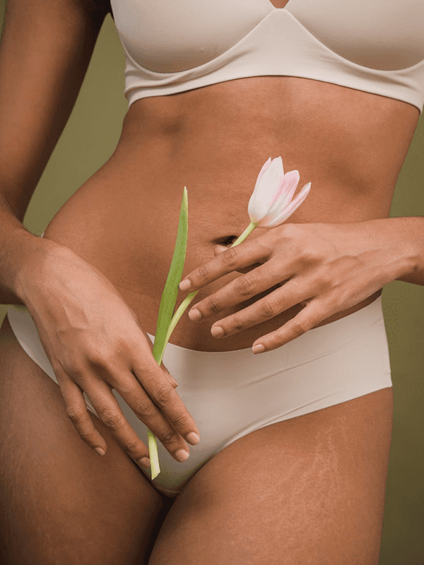 Woman in underwear holds white tulip