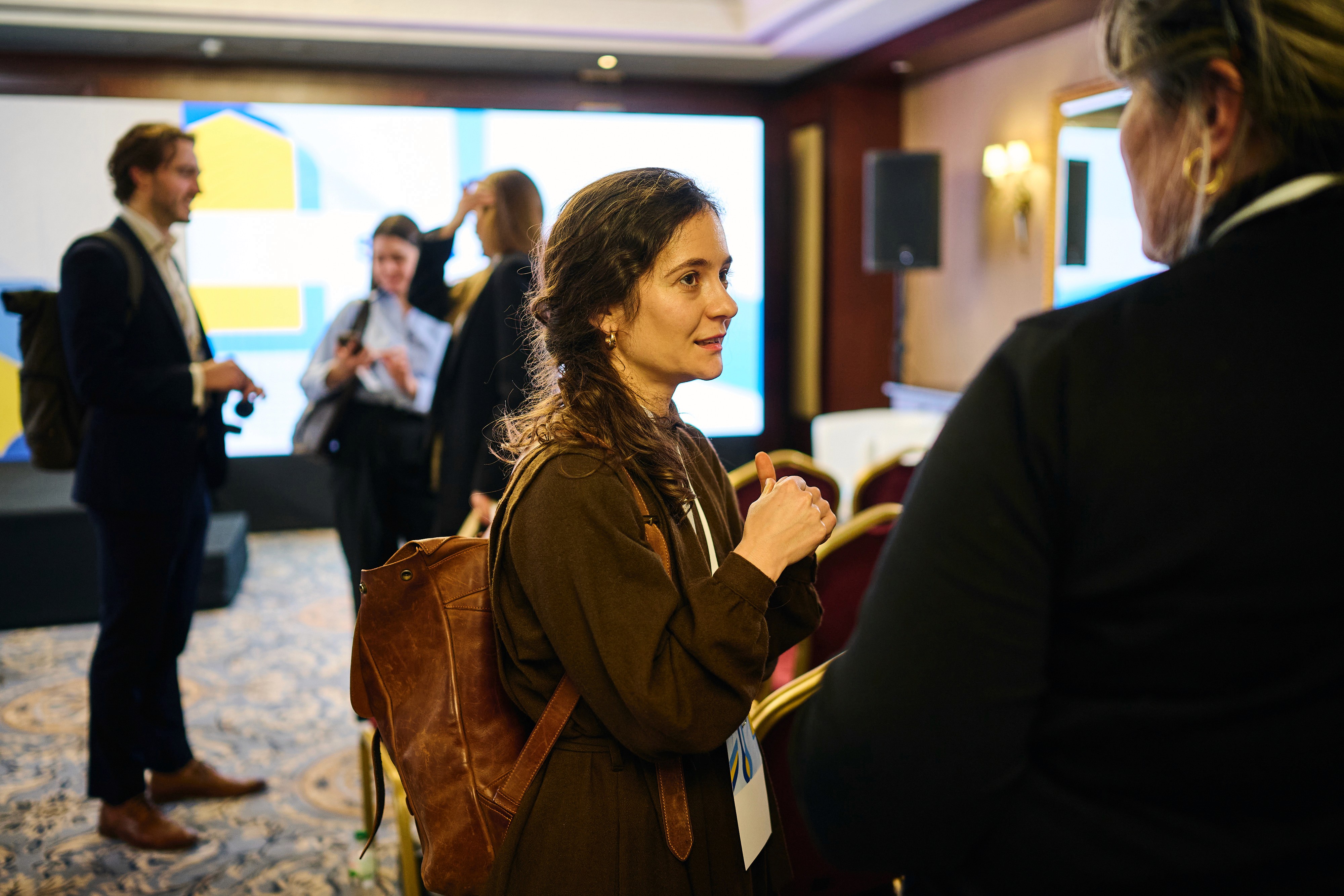 Representative of OPORA Foundation speaking with another attendee at the 2nd Coordination Meeting of the Skills Alliance for Ukraine, in a networking setting.