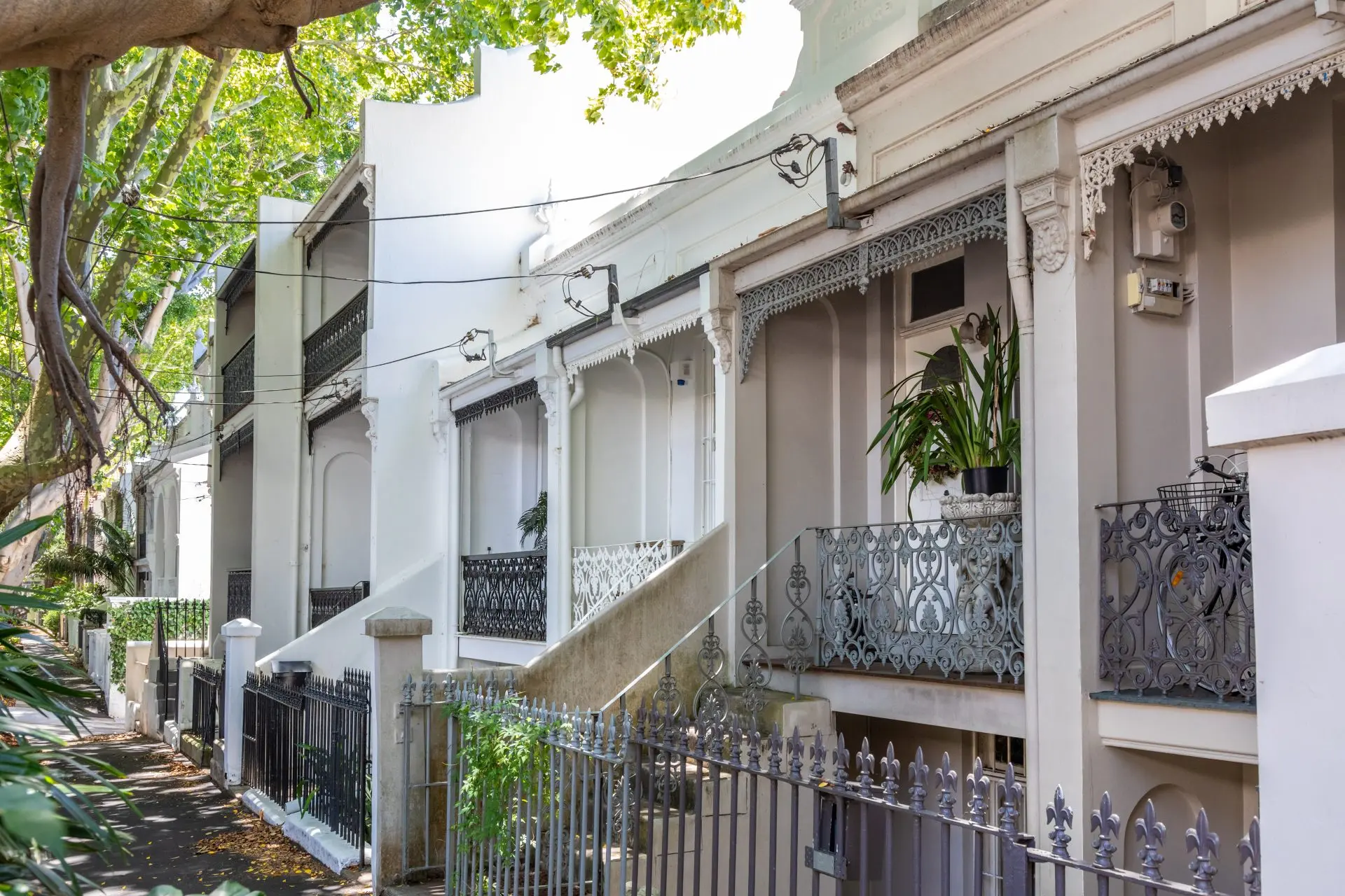 White terrace houses with ornate balconies and fences.