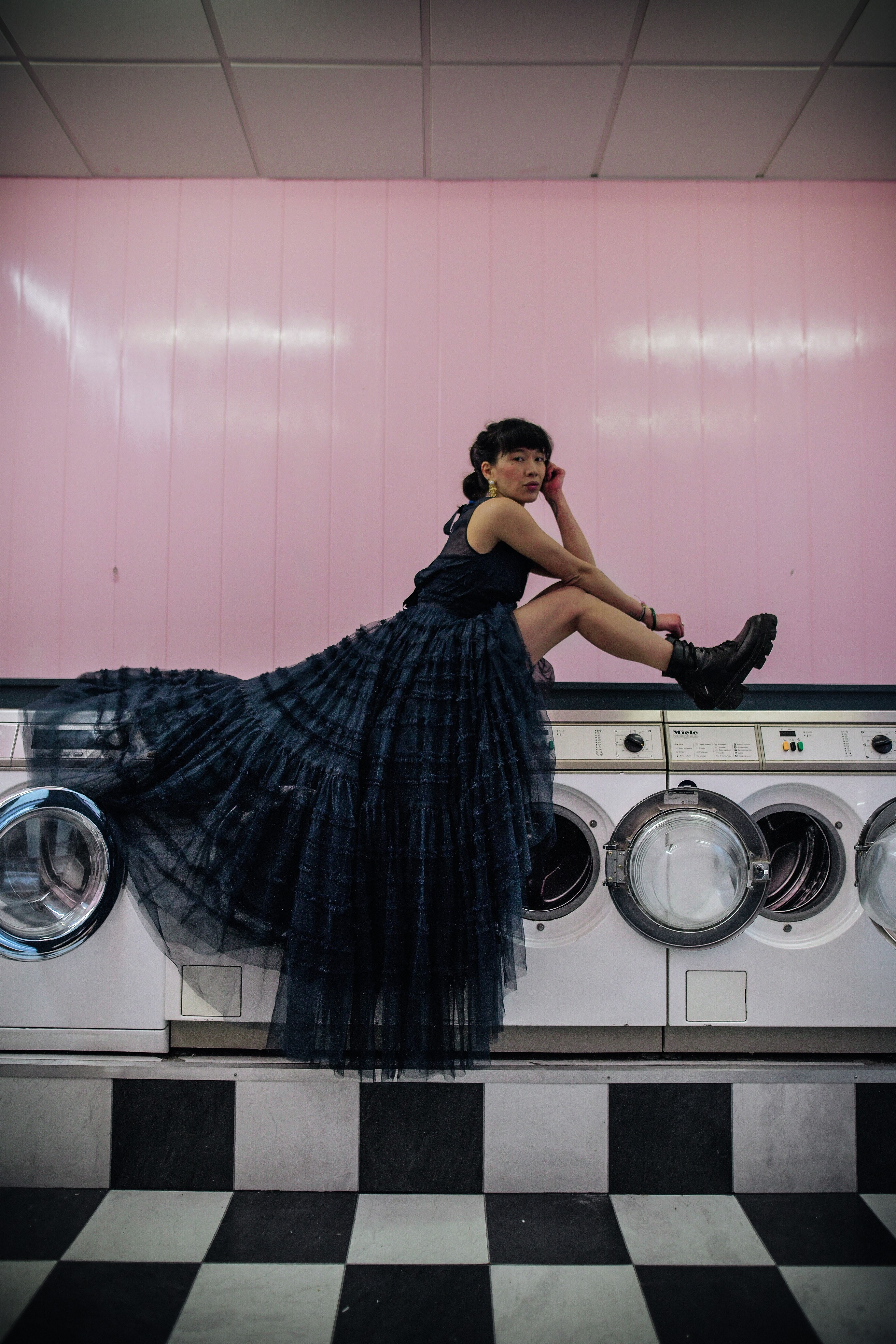 dressing leeloo avec un logue robe noir assise sur des machines à laver