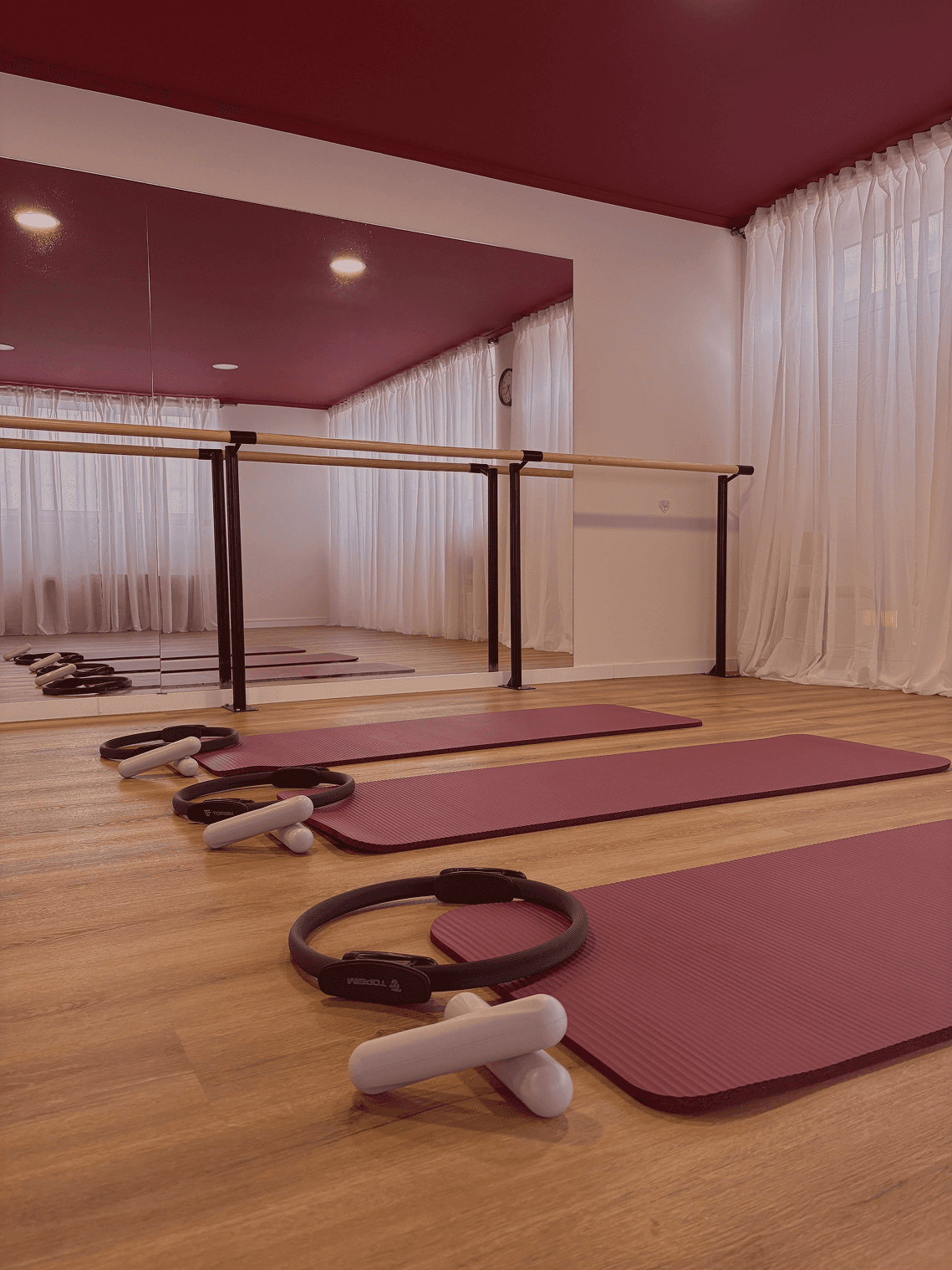 A woman at the beach lying on a pilates mat and rolling backwards.