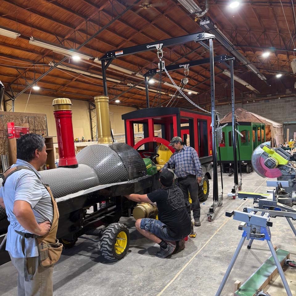 Group of men standing around McNeil Trackless in shop
