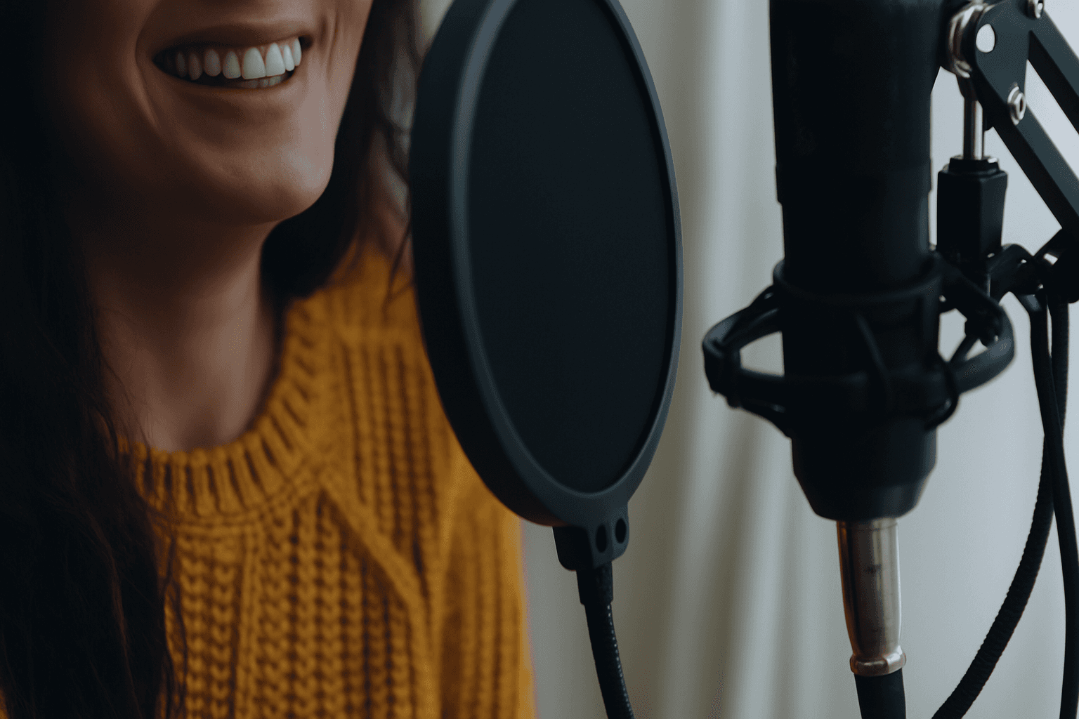 Female voice artist recording narration in a professional studio with a microphone