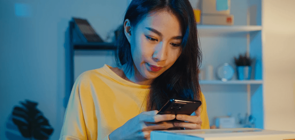 young asian women using here smartphone researching japan esim plans 
