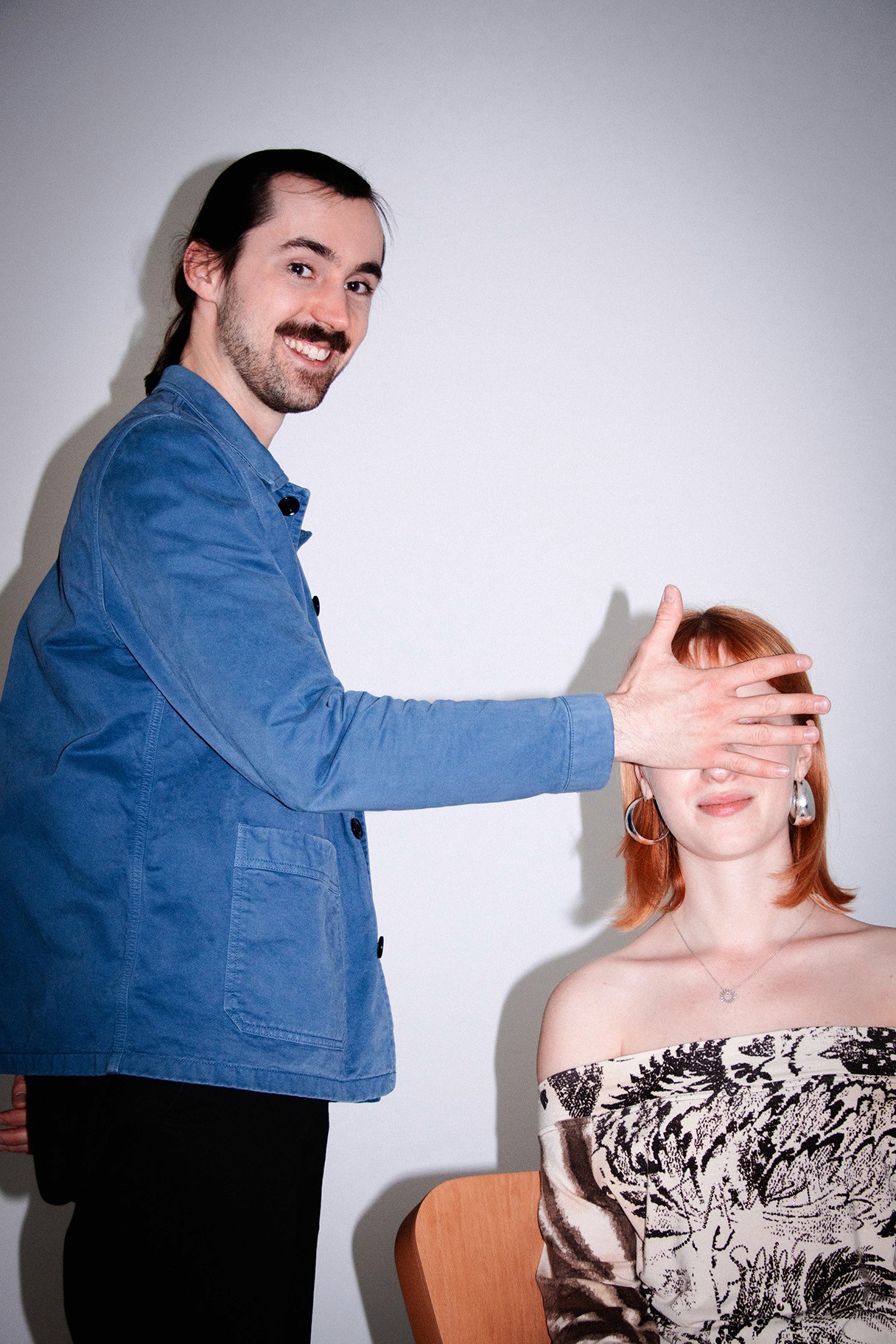 Simon hält lächelnd Leonie die Hand vors Gesicht