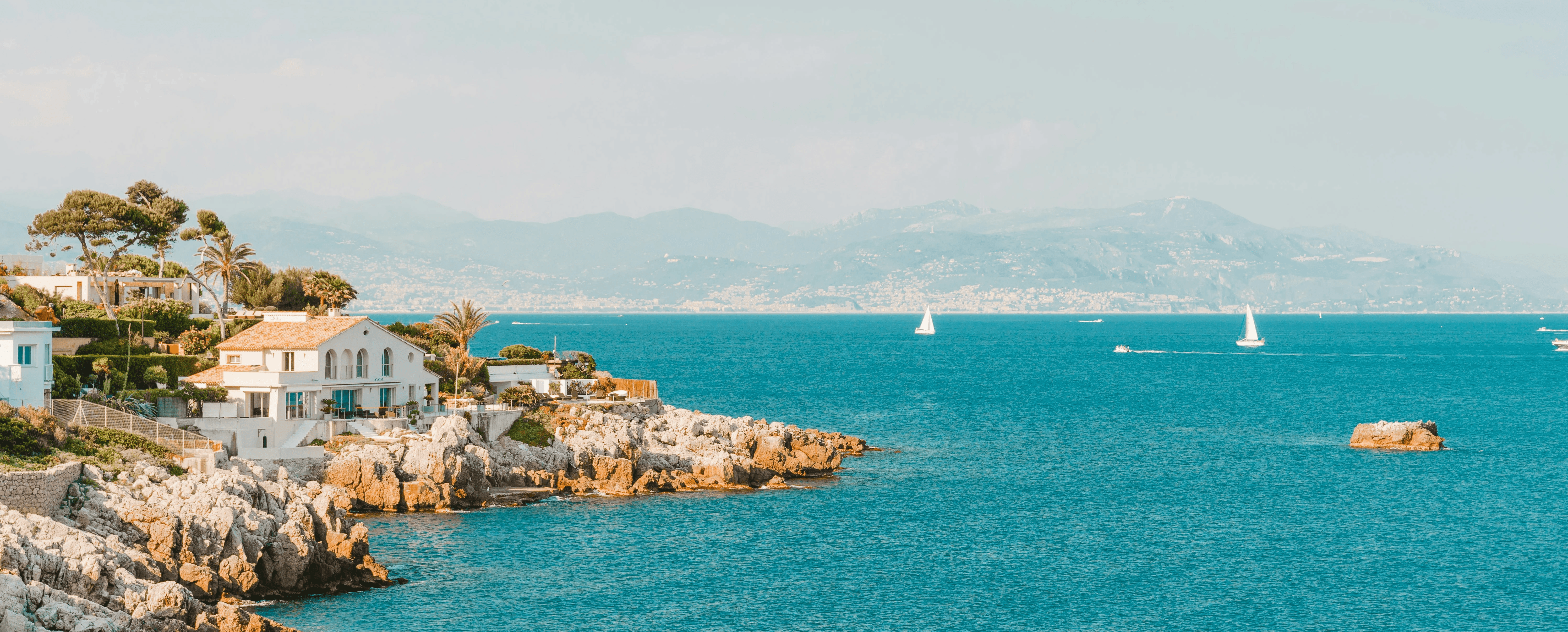 white and brown rock formation on sea under blue sky during daytime