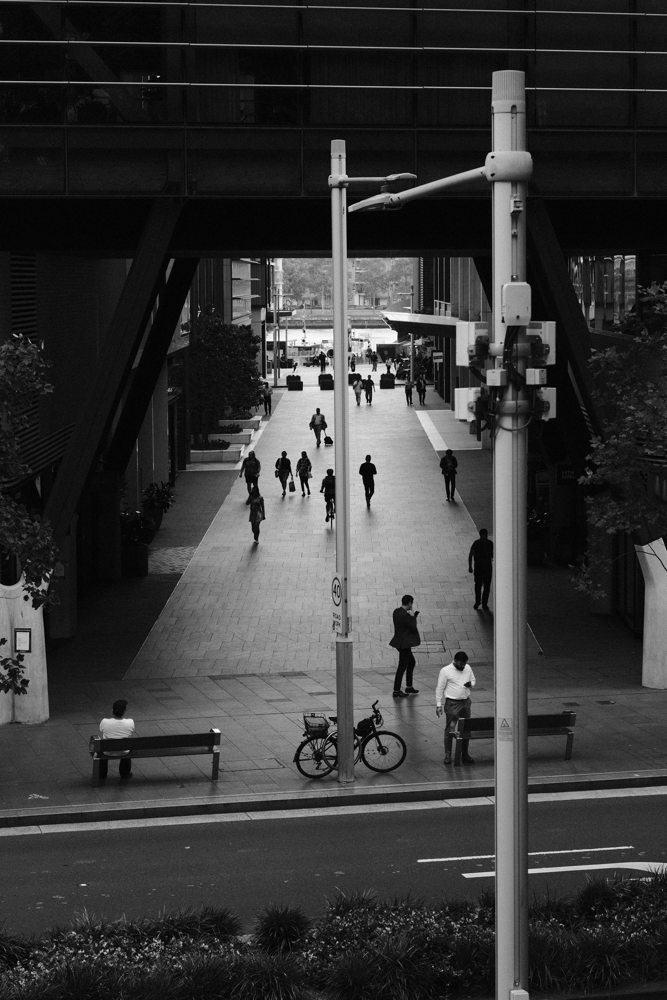A black and white photo of people walking and riding bikes