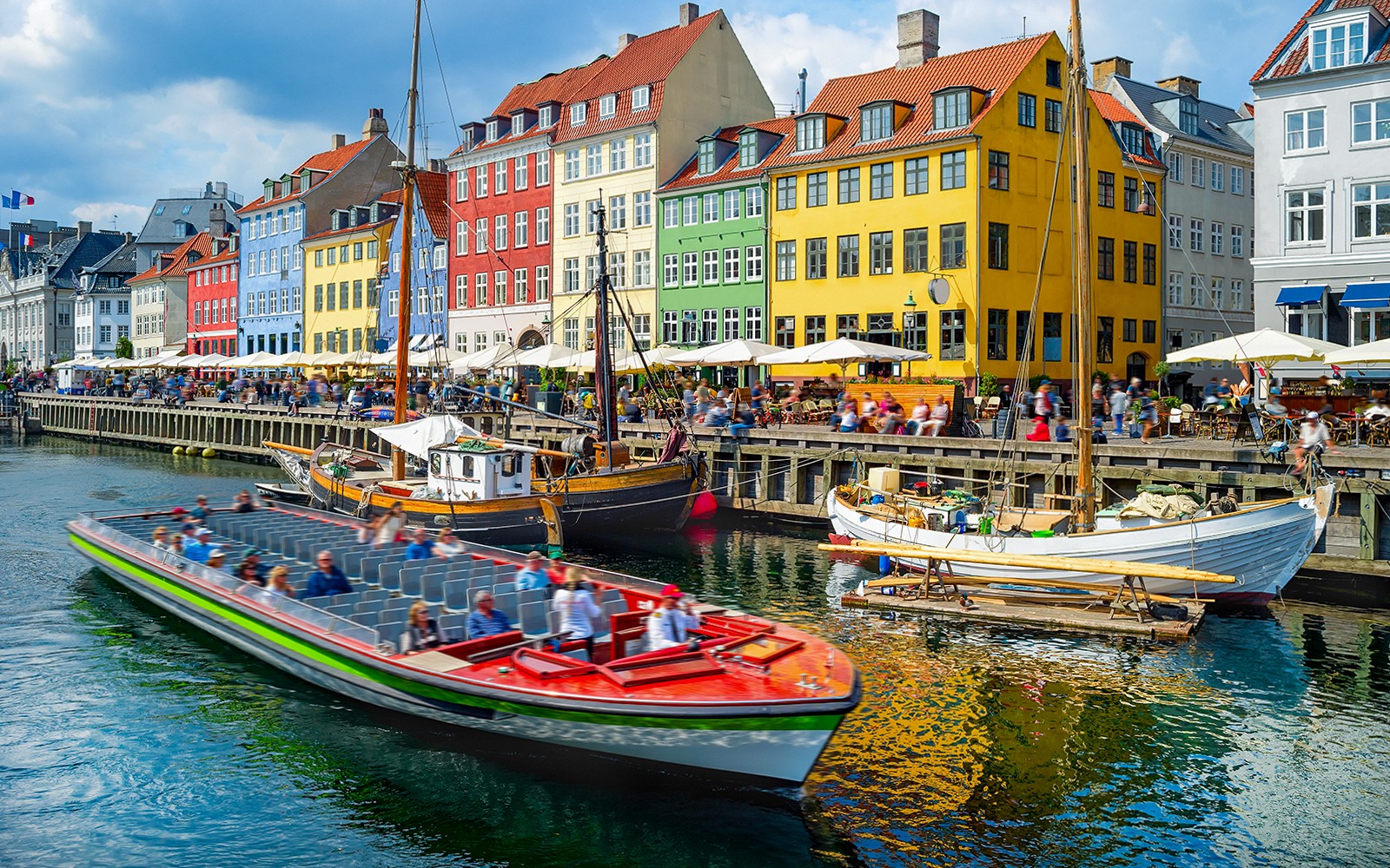 Hajókirándulás színes épületek mellett a Nyhavnban, Koppenhágában.
