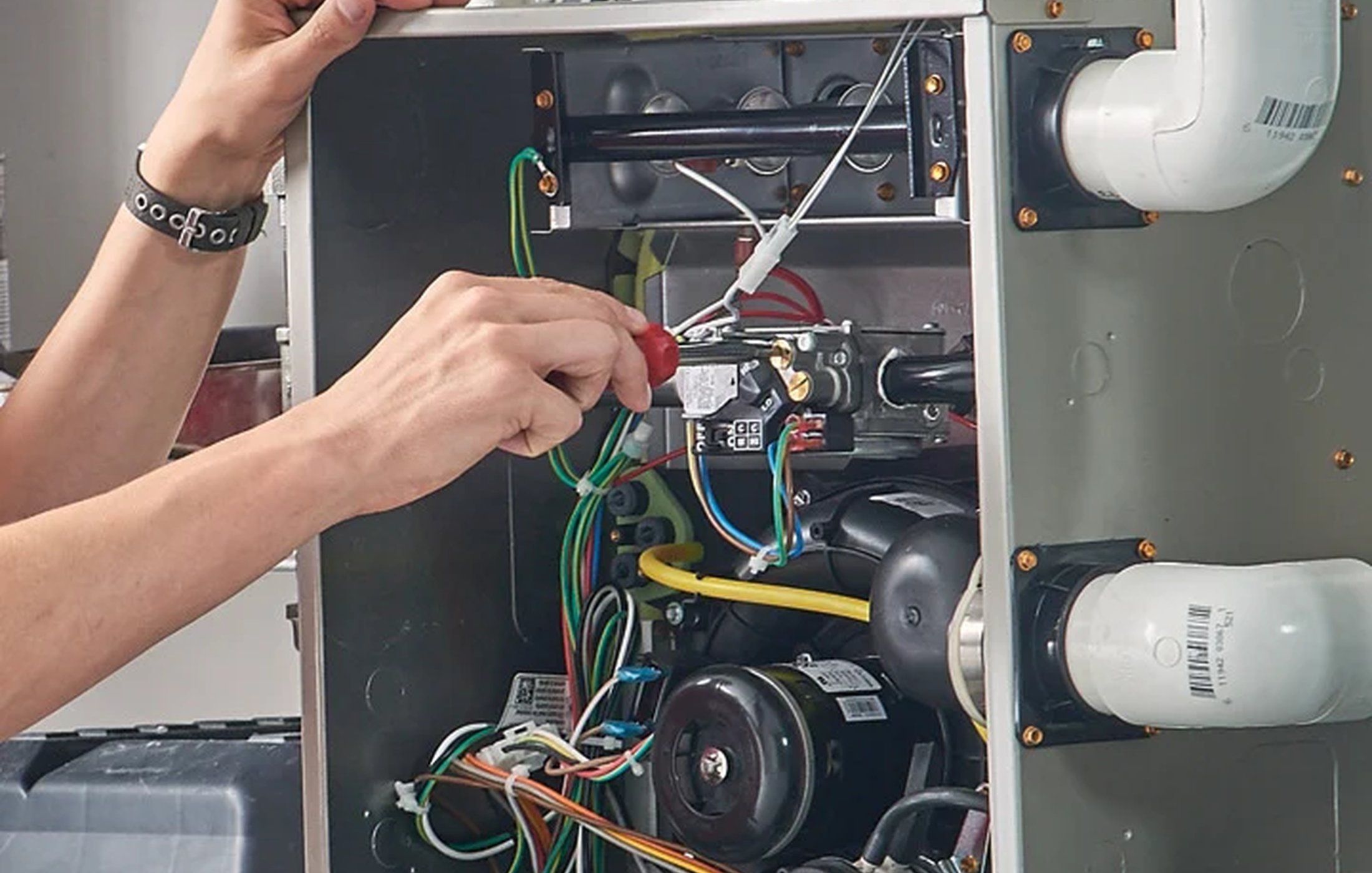 Home HVAC technician mounting an outdoor heat pump system on a wall bracket