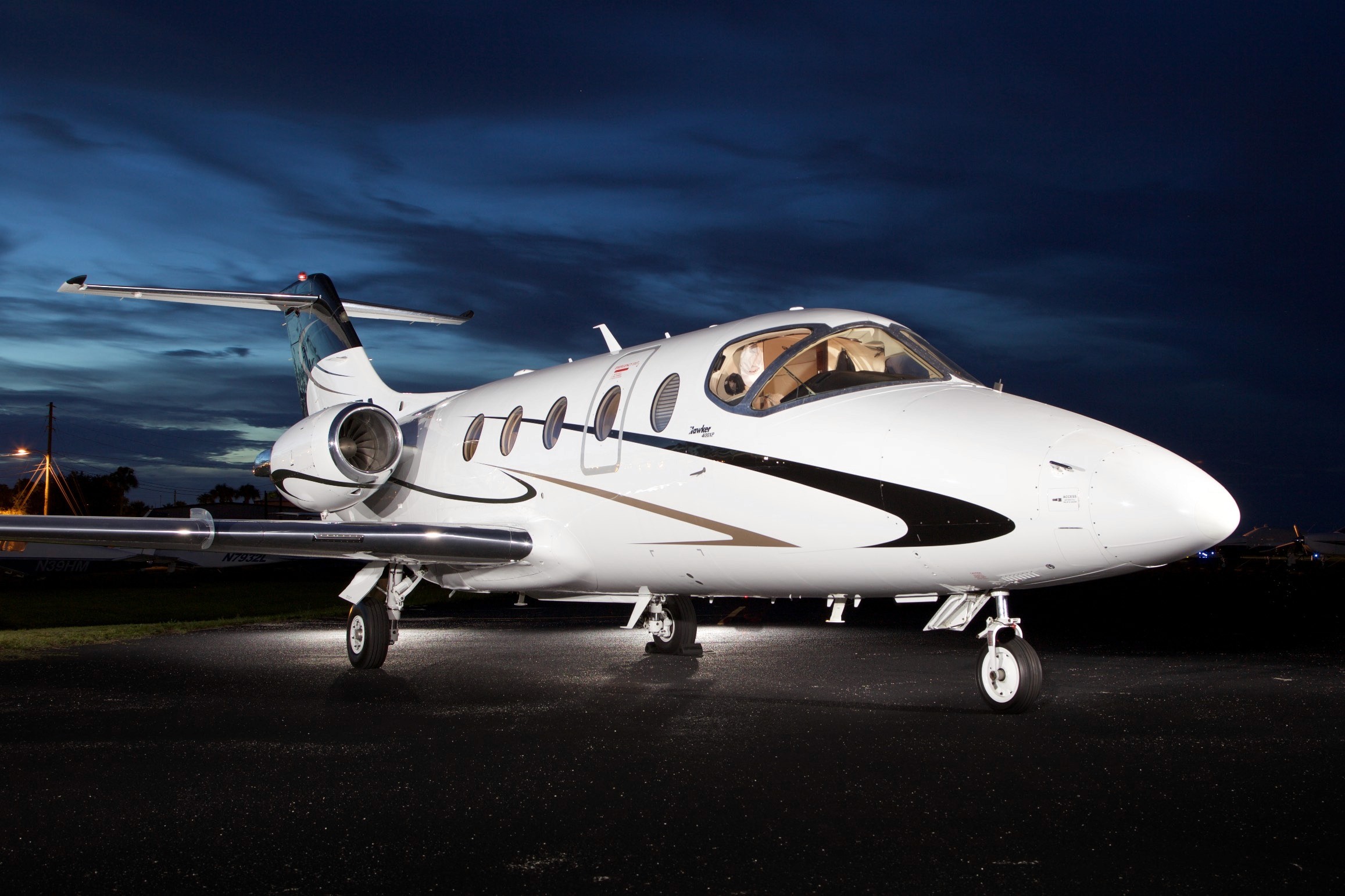 The Hawker 400XP is a light business jet produced by Hawker Beechcraft. It is an improved version of the Beechjet 400, featuring a redesigned interior, more powerful engines, and updated avionics.     The aircraft has a maximum cruising speed of 466 knots (539 mph) and a maximum range of 1,741 nautical miles (2,001 miles). It can accommodate up to 9 passengers in a standard configuration and features a spacious cabin with a stand-up height of 4 feet 8 inches.     The Hawker 400XP is powered by two Pratt & Whitney Canada JT15D-5R turbofan engines, each providing 2,965 pounds of thrust. The aircraft has a maximum takeoff weight of 16,280 pounds and can operate from runways as short as 3,500 feet.     The cockpit of the Hawker 400XP is equipped with a Rockwell Collins Pro Line 4 avionics suite, which includes a flight management system, weather radar, and traffic collision avoidance system. The aircraft also features an optional Aircell satellite phone system for inflight communication.     Overall, the Hawker 400XP is a popular choice for small to midsize businesses and private jet owners looking for a comfortable and efficient aircraft for short to medium range travel.