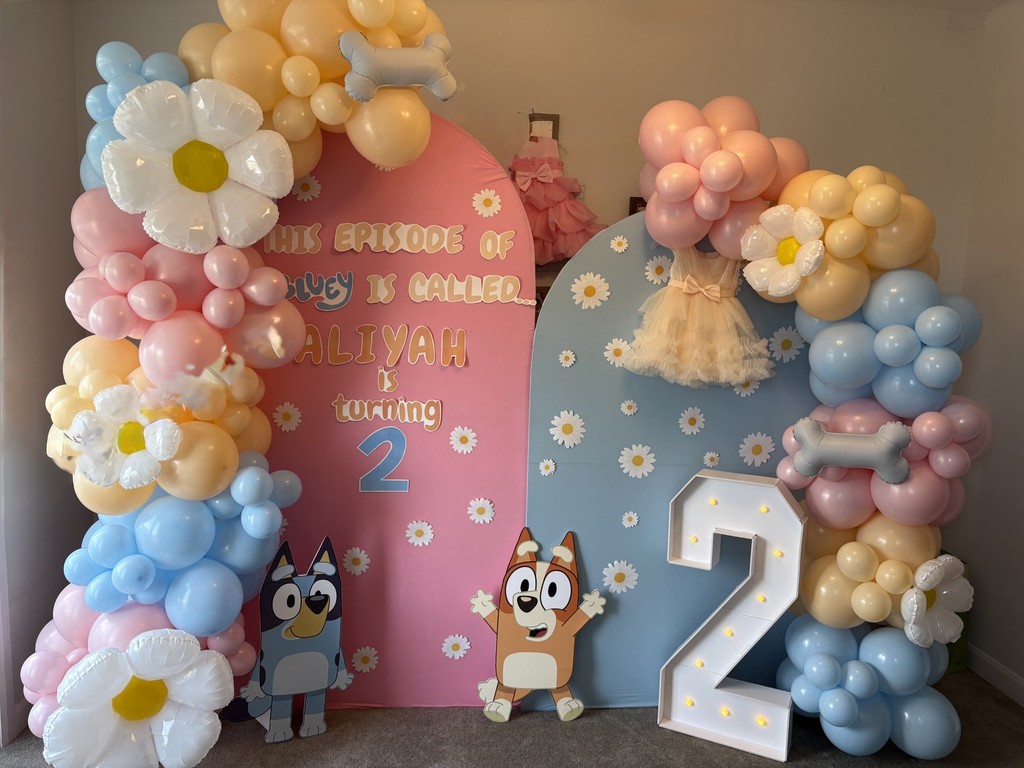 Balloon arch with big 15 inch balloons and 7 inch ballloons in the colours black, purple and blue. The arch is black and has happy birthday sign. The theme is based out of fortnite video game.