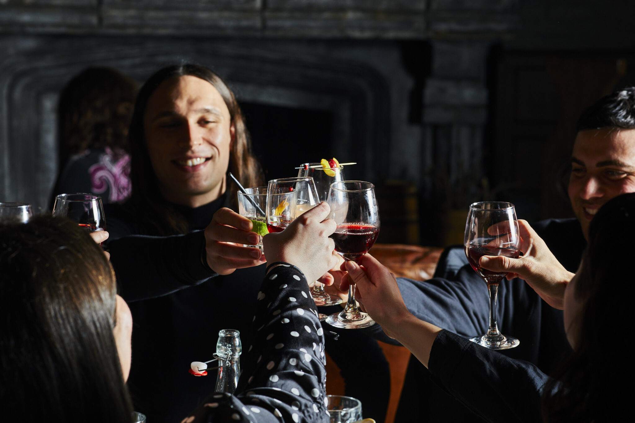 Group of friends do a cheers with glasses of wine and cocktails in the Fortress Tavern