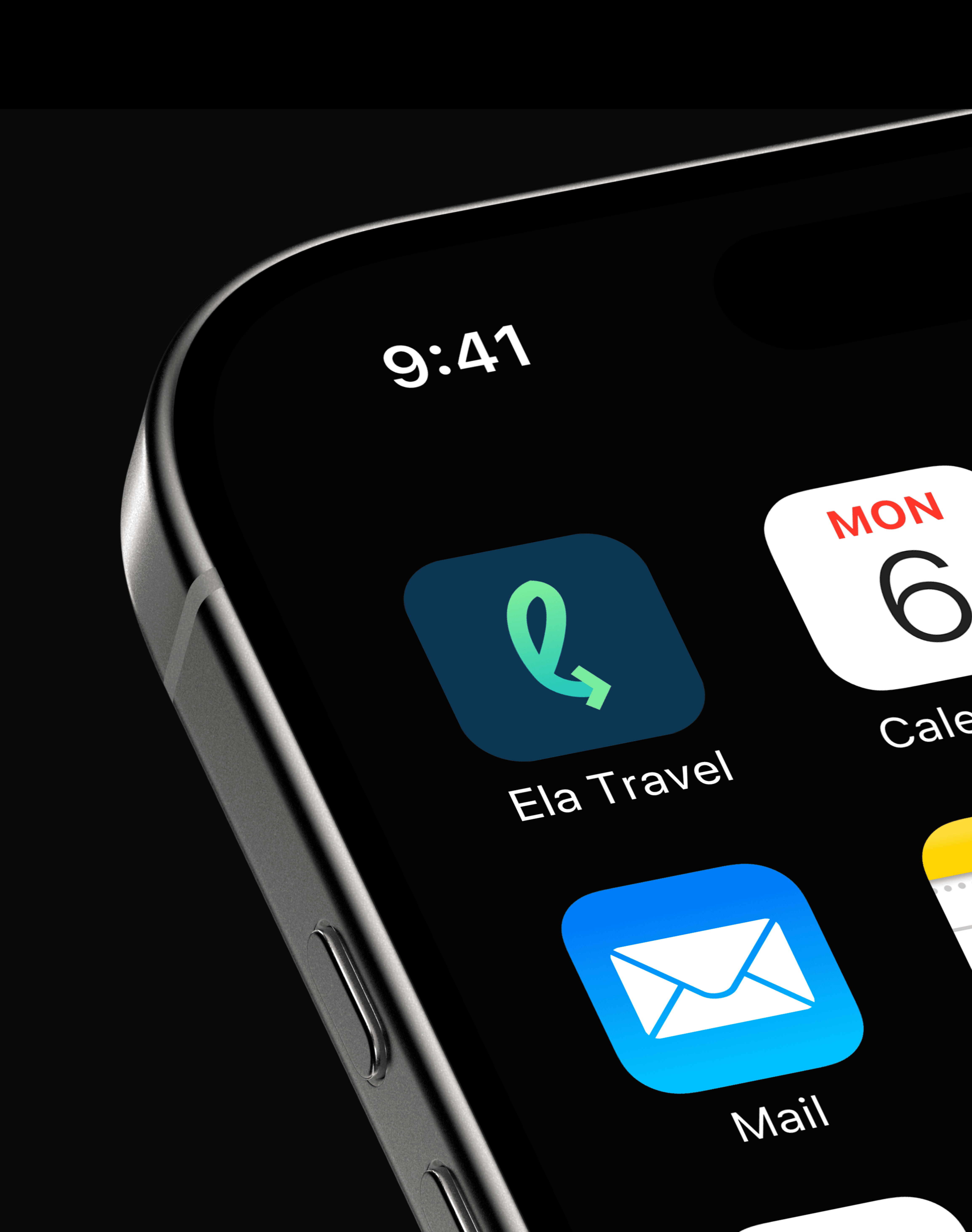 A young person with curly hair smiles at the camera while sitting in front of a laptop against a dark background.