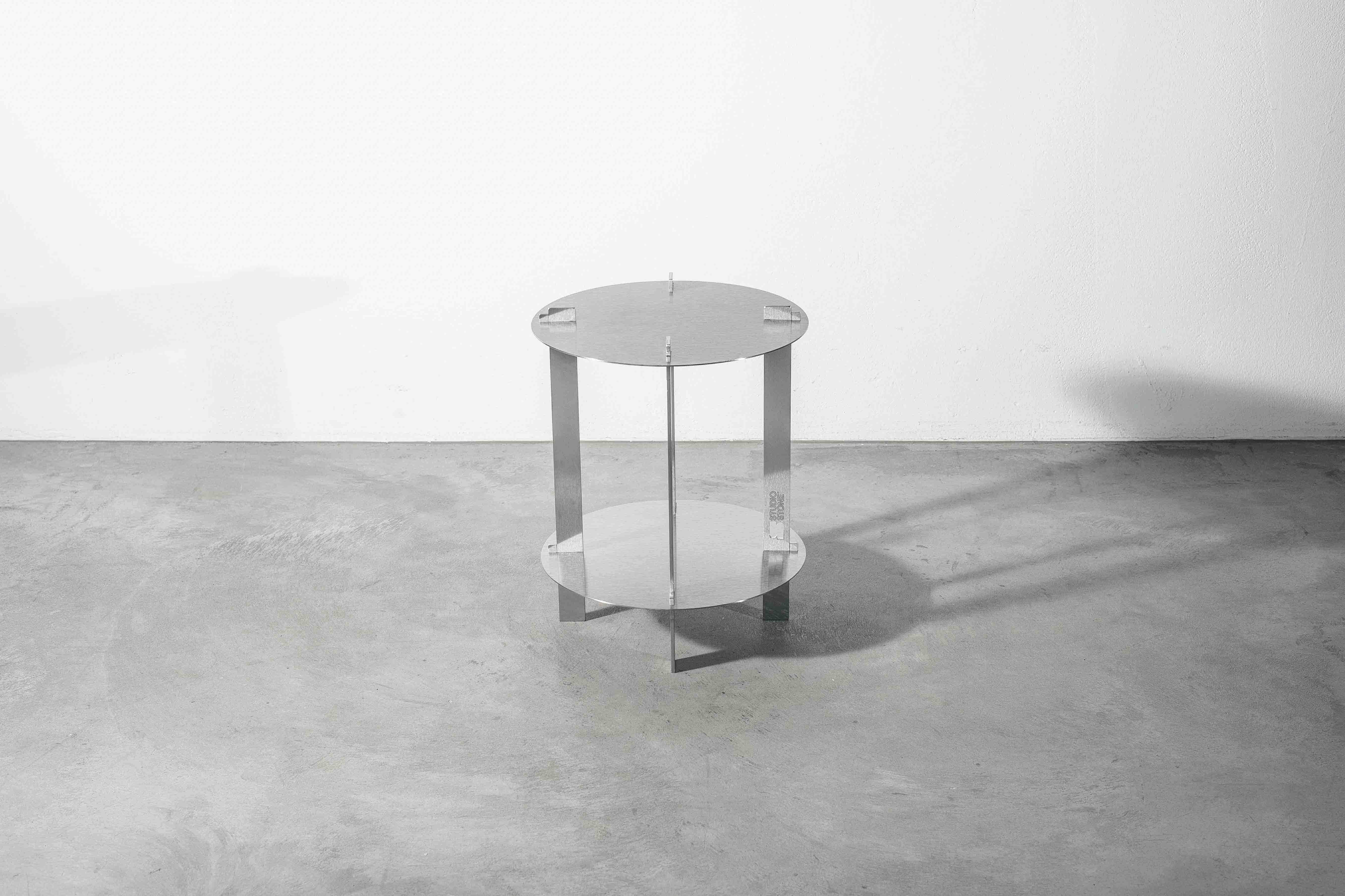 a metal designer table on a concrete floor