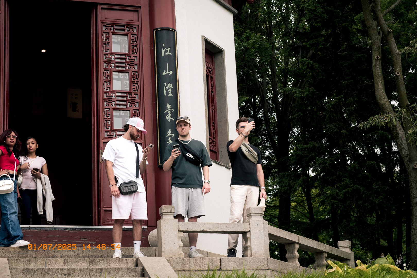 Groupe de visiteurs devant un pavillon chinois traditionnel au jardin botanique.