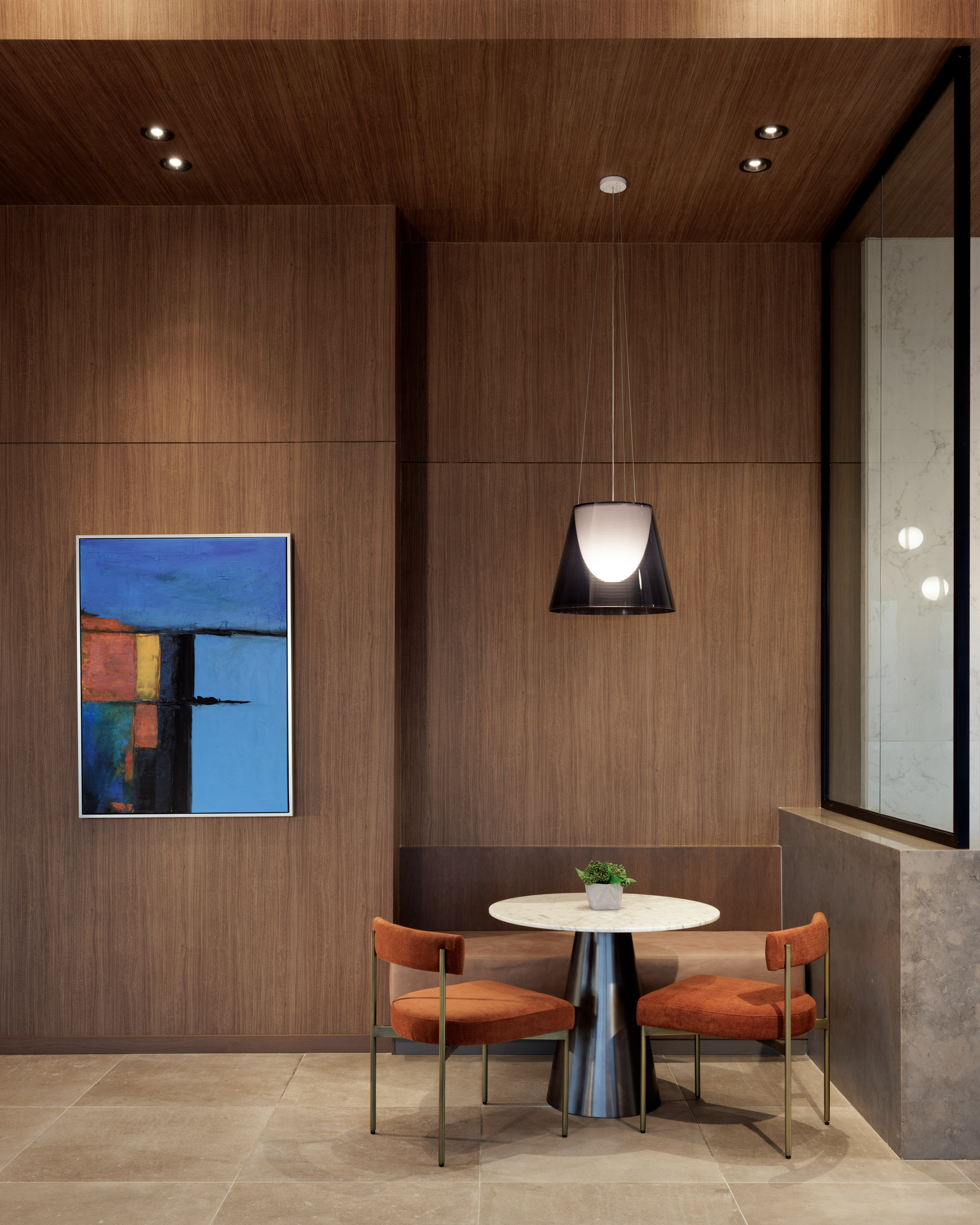 Modern seating area with artwork and pendant lamp.