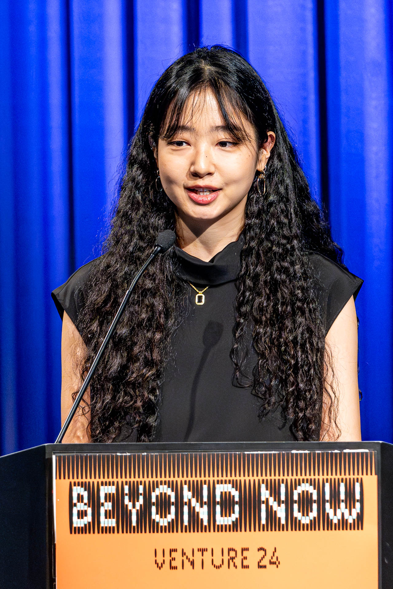 a student at a podium presenting a project in a Theatre