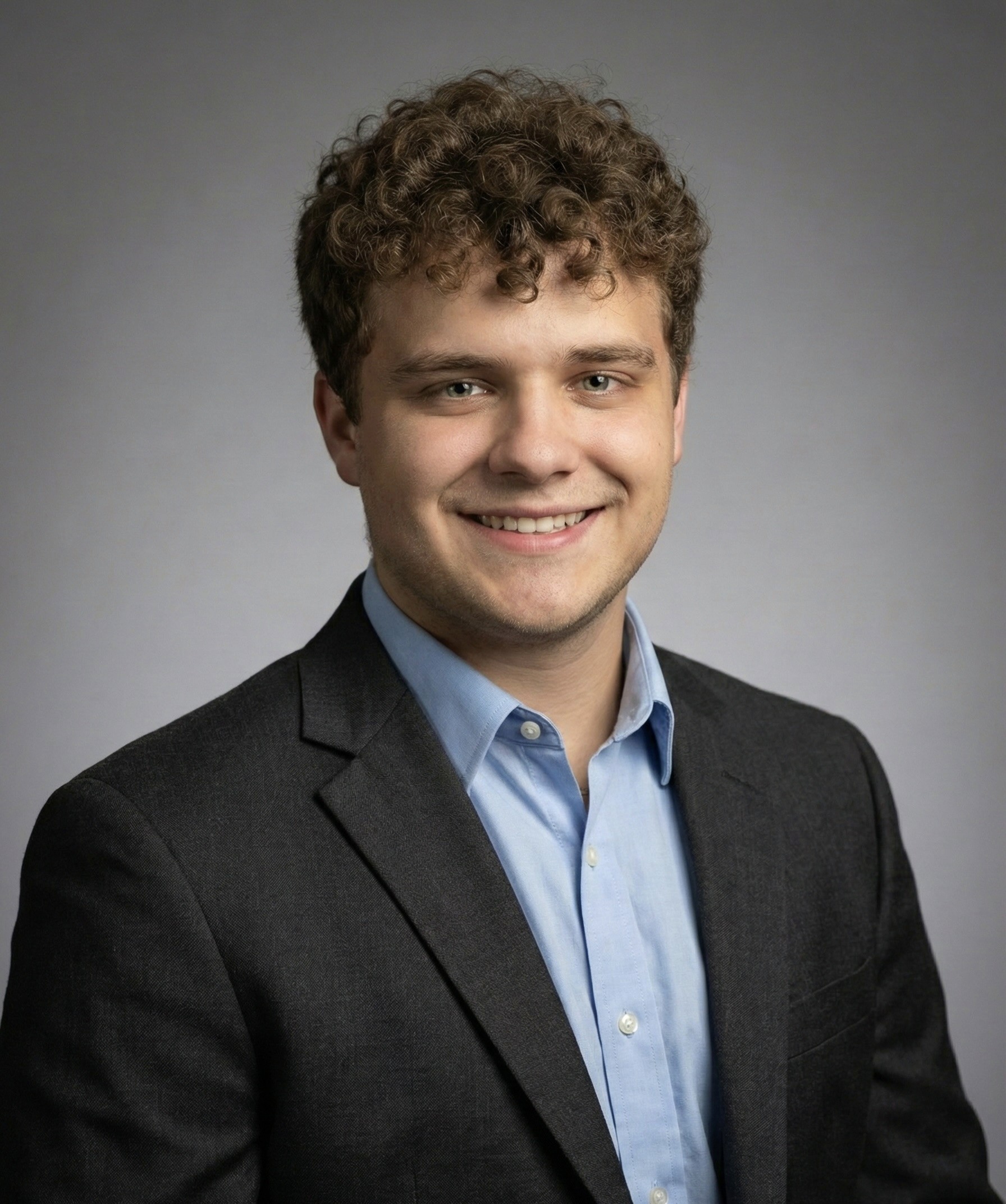 Portrait of a person in a pink sweater against a light background