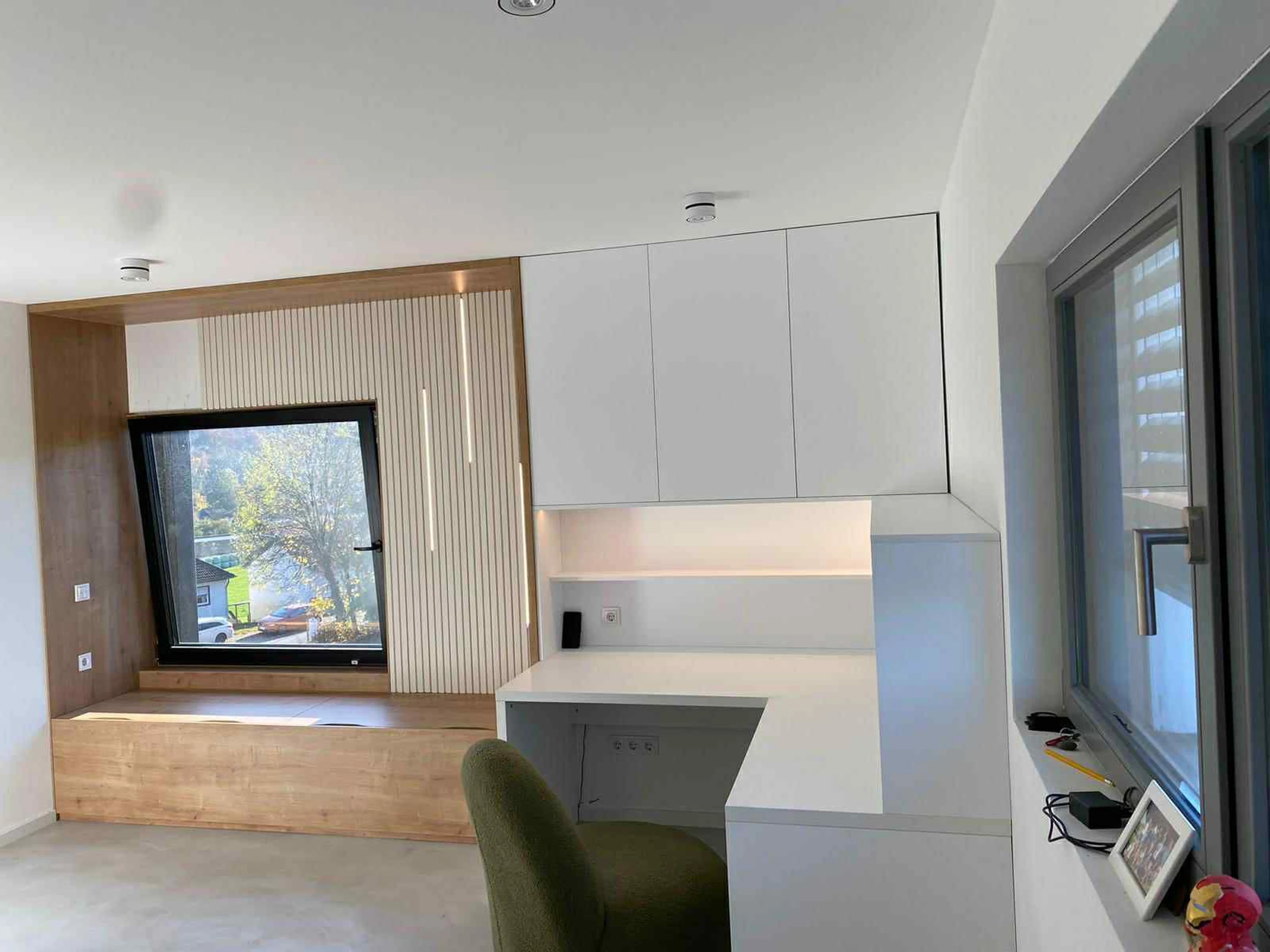 Bureau intégré sur mesure avec banquette sous fenêtre, rangements et LED discrètes — aménagement intérieur au Luxembourg.