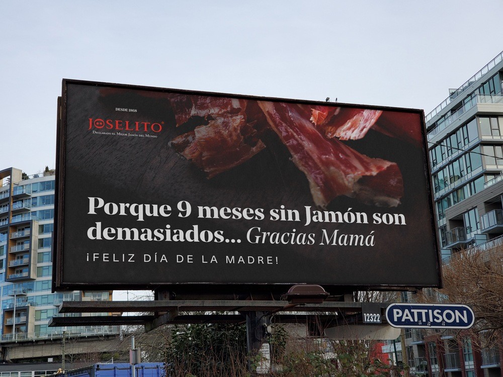 Una cartelera en el exterior que reza "Porque 9 meses sin jamón son demasiados... Gracias Mamá ¡Feliz día de la madre!"